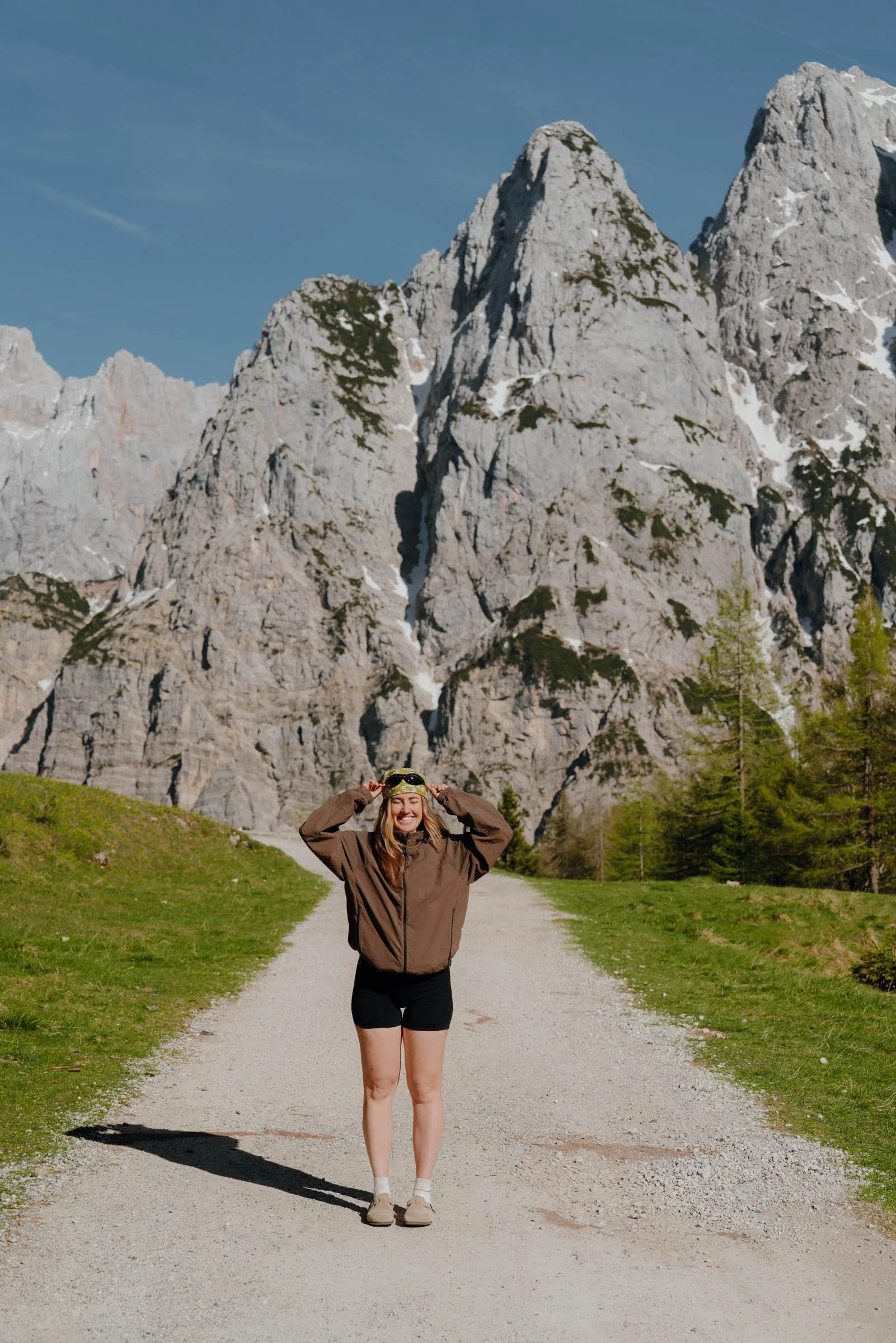 A woman in hiking gear posing for the camera in front of Slovenia's massive mountains