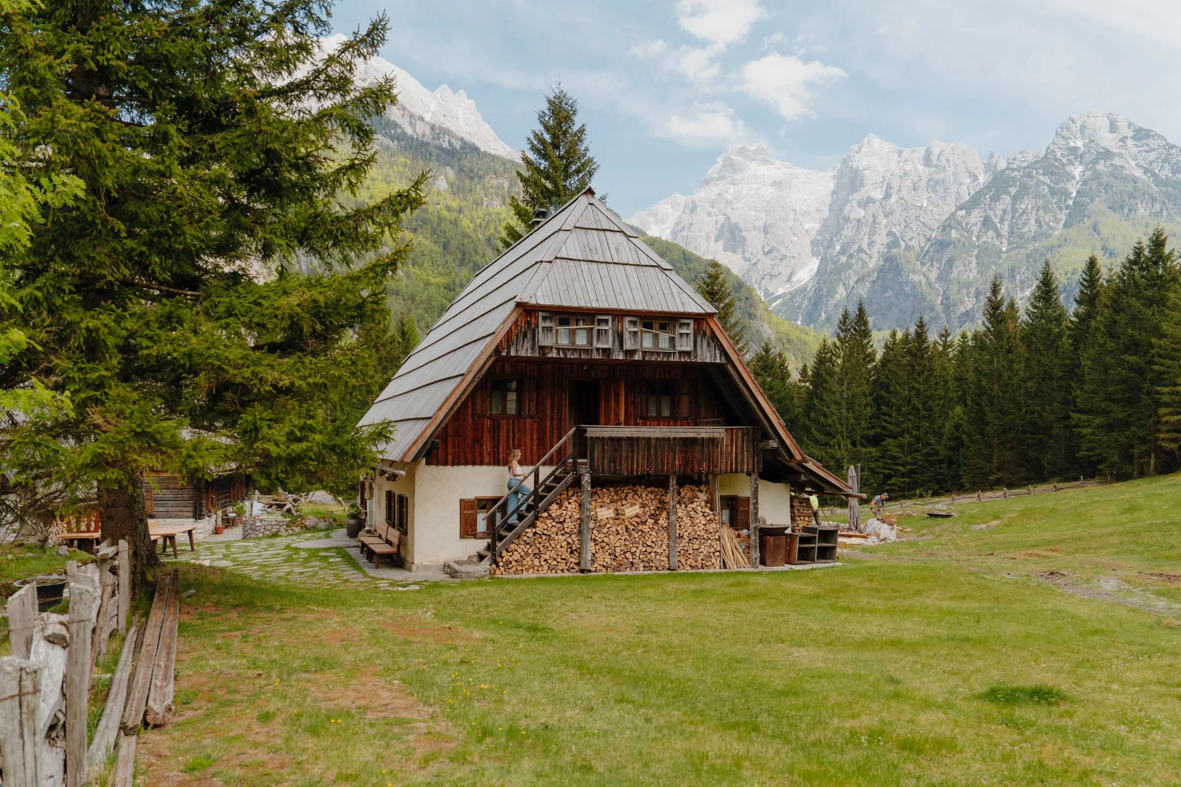 Woman walking up the stairs of a quaint mountain hut on the Kekčeva Domačija, Alpe Adria Trail, Slovenia