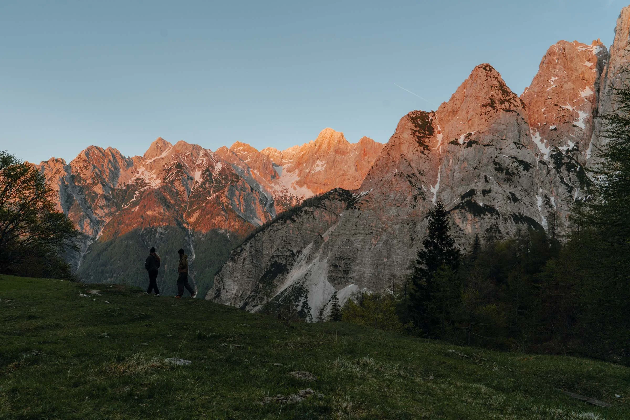 two women in front of glowing mountains at sunset