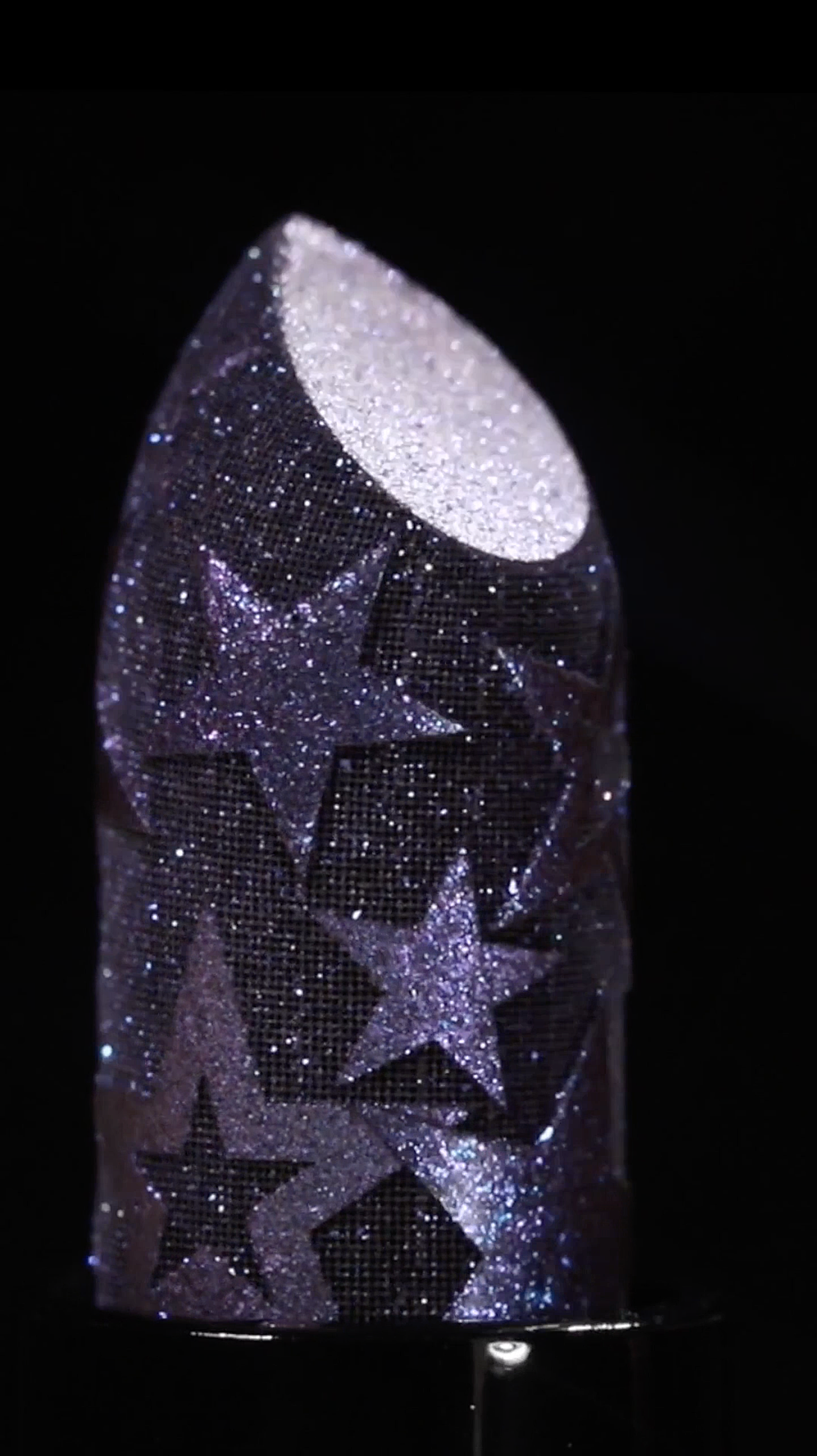 Lunar meteorite modeled with glittery stars and moon surface, illuminated against a black background.