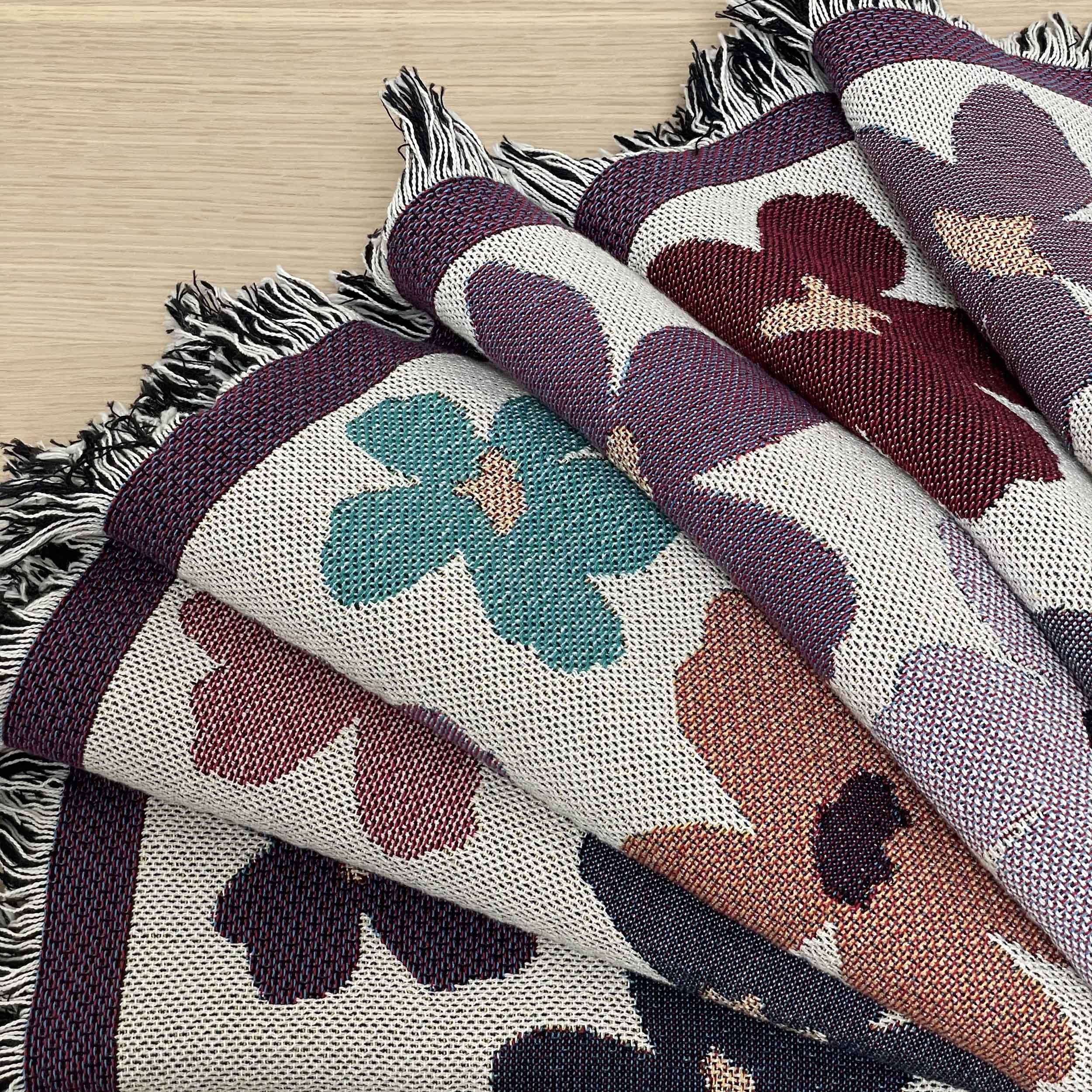 Throw blanket featuring abstract flowers draped on wooden table