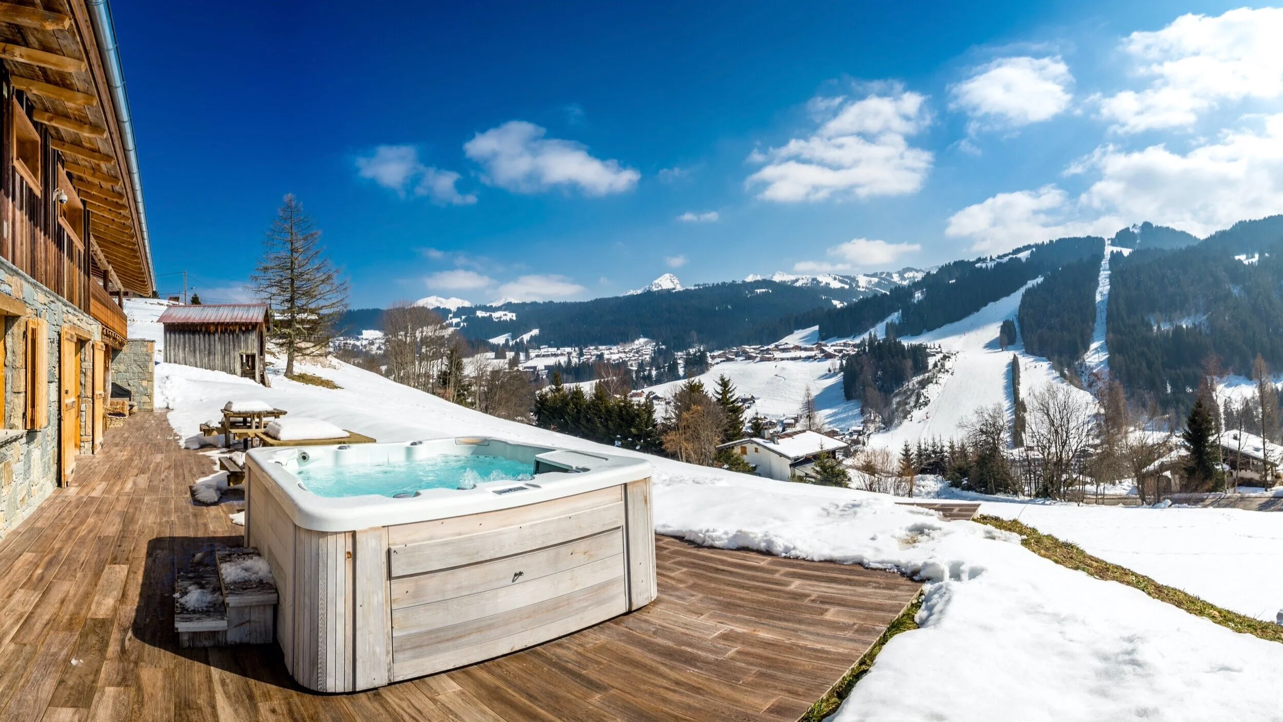 Explore vacation rentals: a mountain chalet deck with a hot tub and snowy views