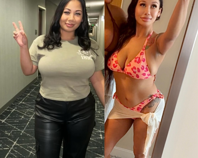 A woman taking a mirror selfie in lingerie with a pink and red heart pattern and a beige wrap skirt in a room. She has long dark hair and is posing with one arm raised and a slight smile.