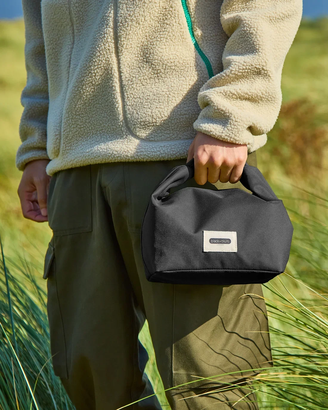black-blum-new-lunch-bag-black-closed-carried_86f36c4e-8ae6-4cd8-b8e5-a654a838600a.webp