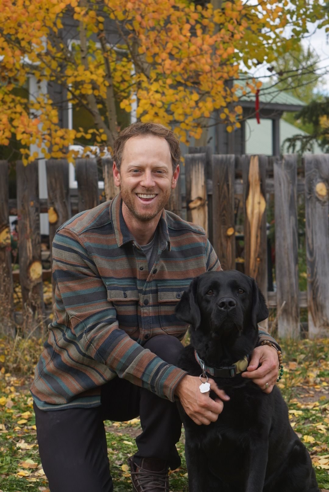 “Professional in-home dog sitting with black Labrador outdoors in fall”