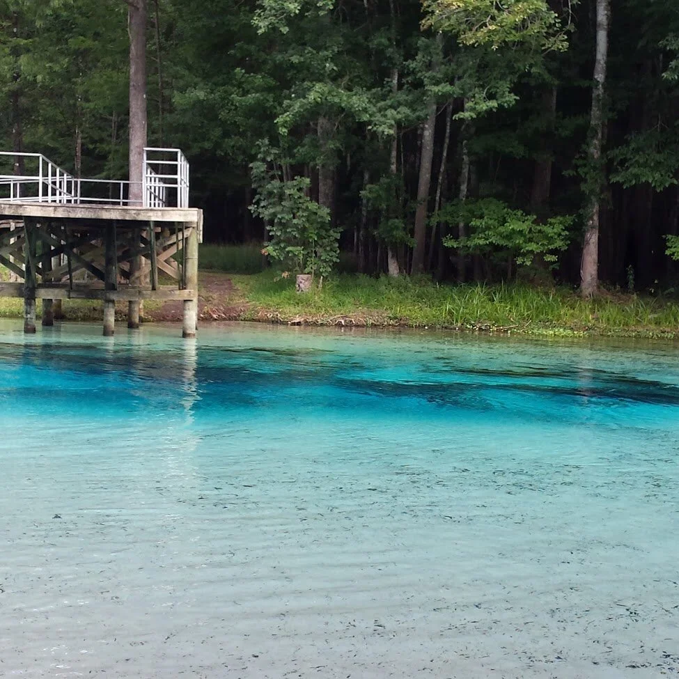 alt= "peaceful blue green water with dock"
