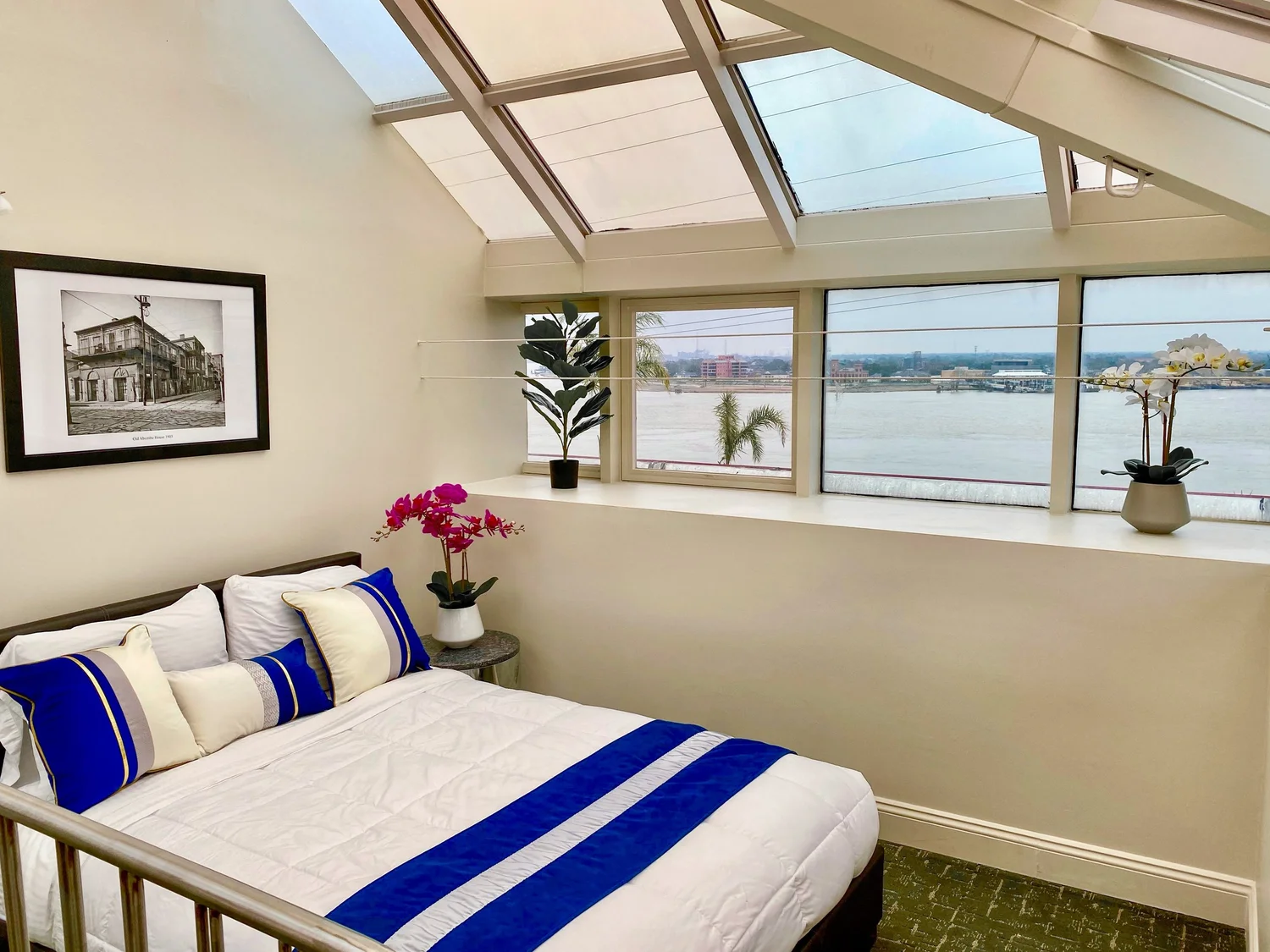 Bedroom with skylights, river view and blue-and-white bedding in The Penthouse at Jax Brewery