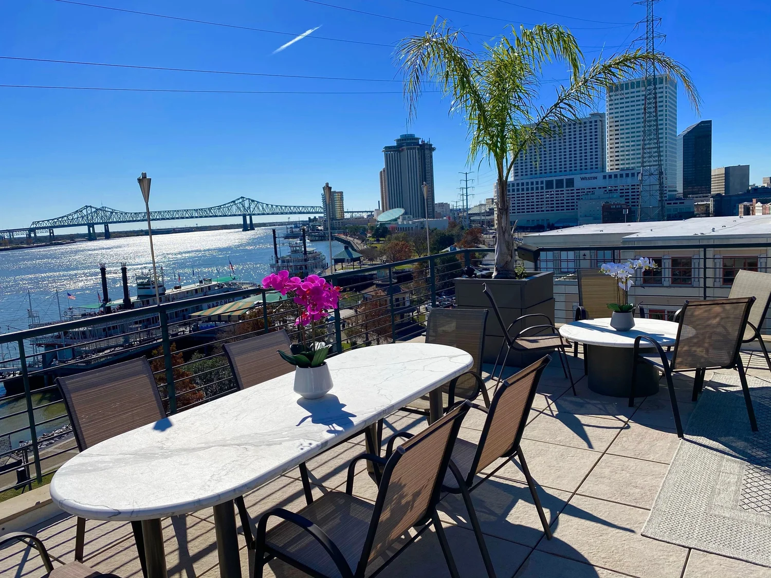 Sunny rooftop dining deck overlooking the Mississippi River at Jax Brewery in the French Quarter of New Orleans