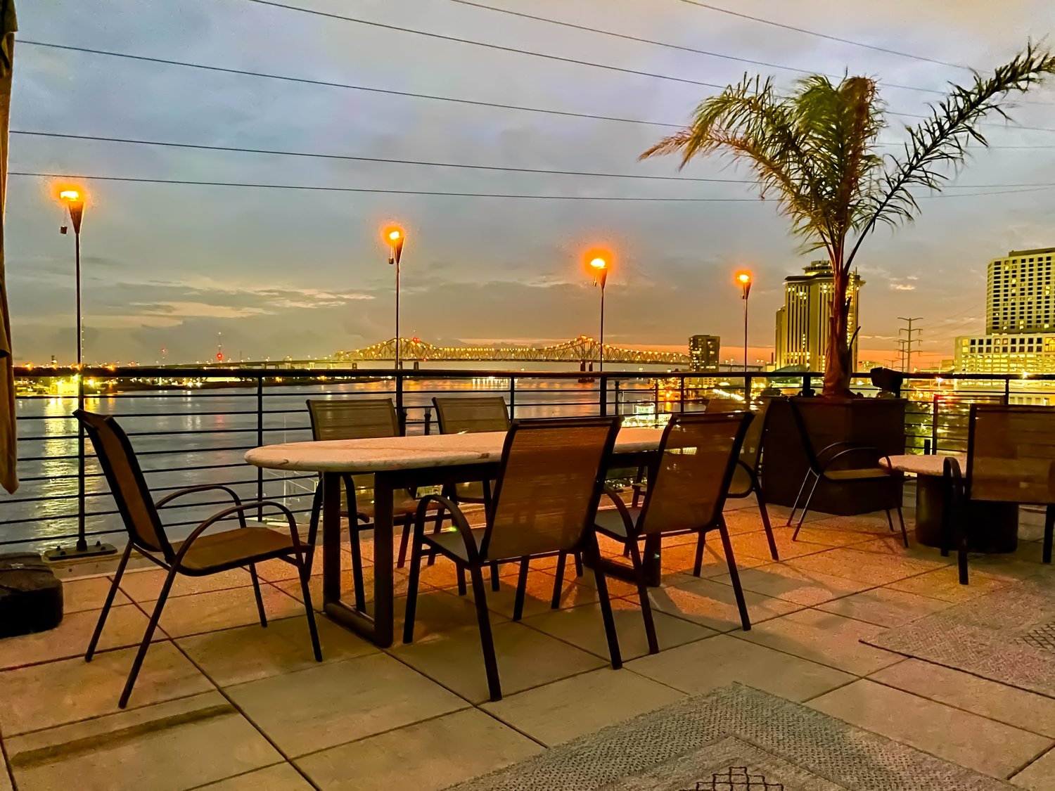 Outdoor dining terrace at dusk overlooking the Mississippi River at The Penthouse at Jax Brewery