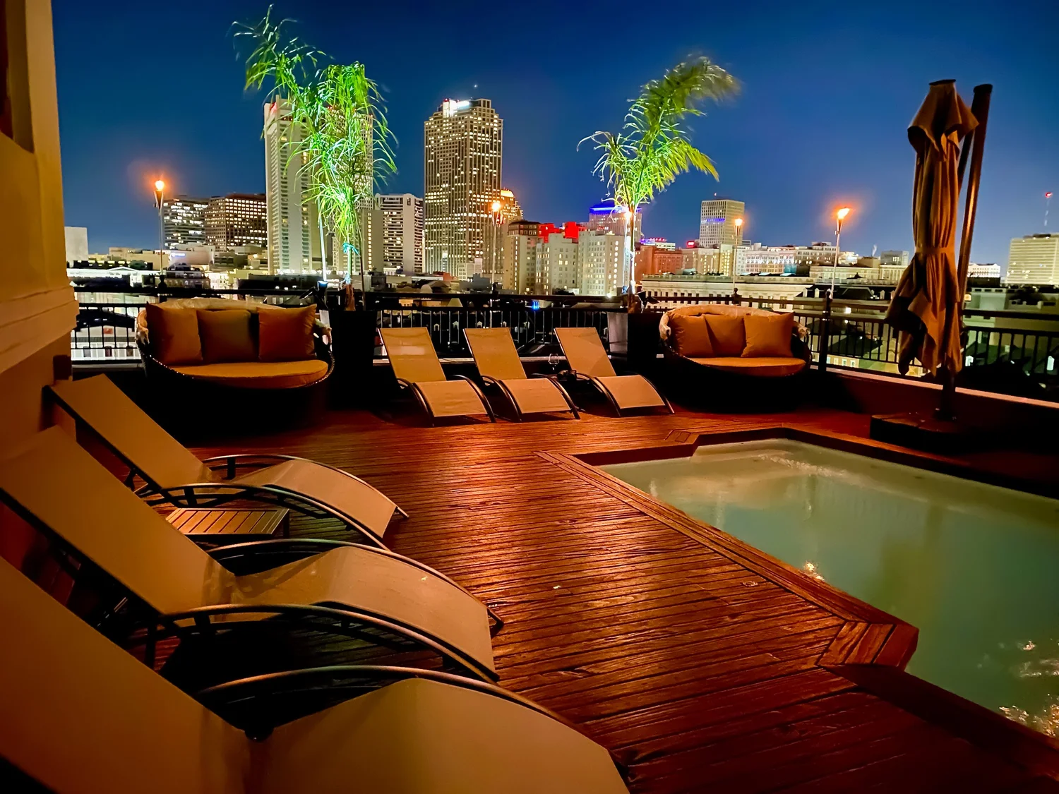Rooftop pool and lounge chairs lit at night at The Penthouse at Jax Brewery in the French Quarter