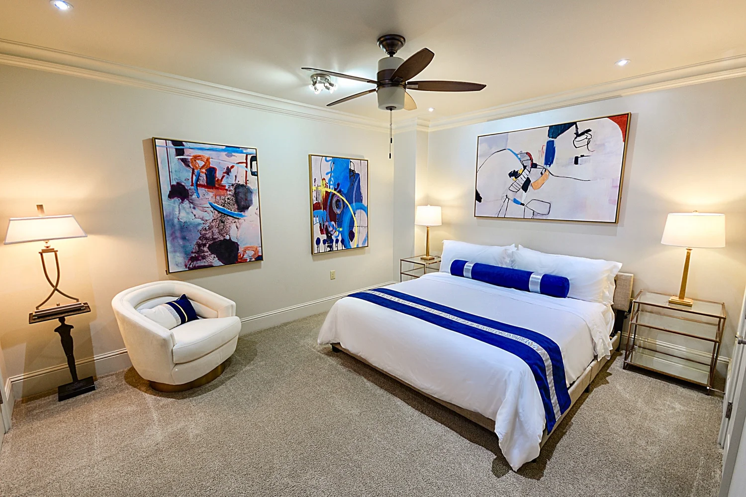 King bedroom with blue-striped bedding in the Jax Brewery 1-bedroom condo