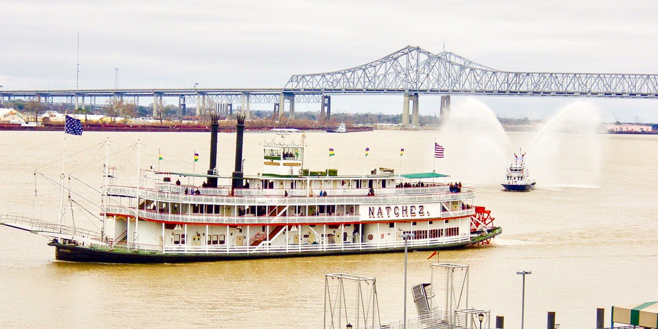 Steamboat Natchez on the Mississippi River with the Crescent City Connection bridge, seen from Jax Brewery