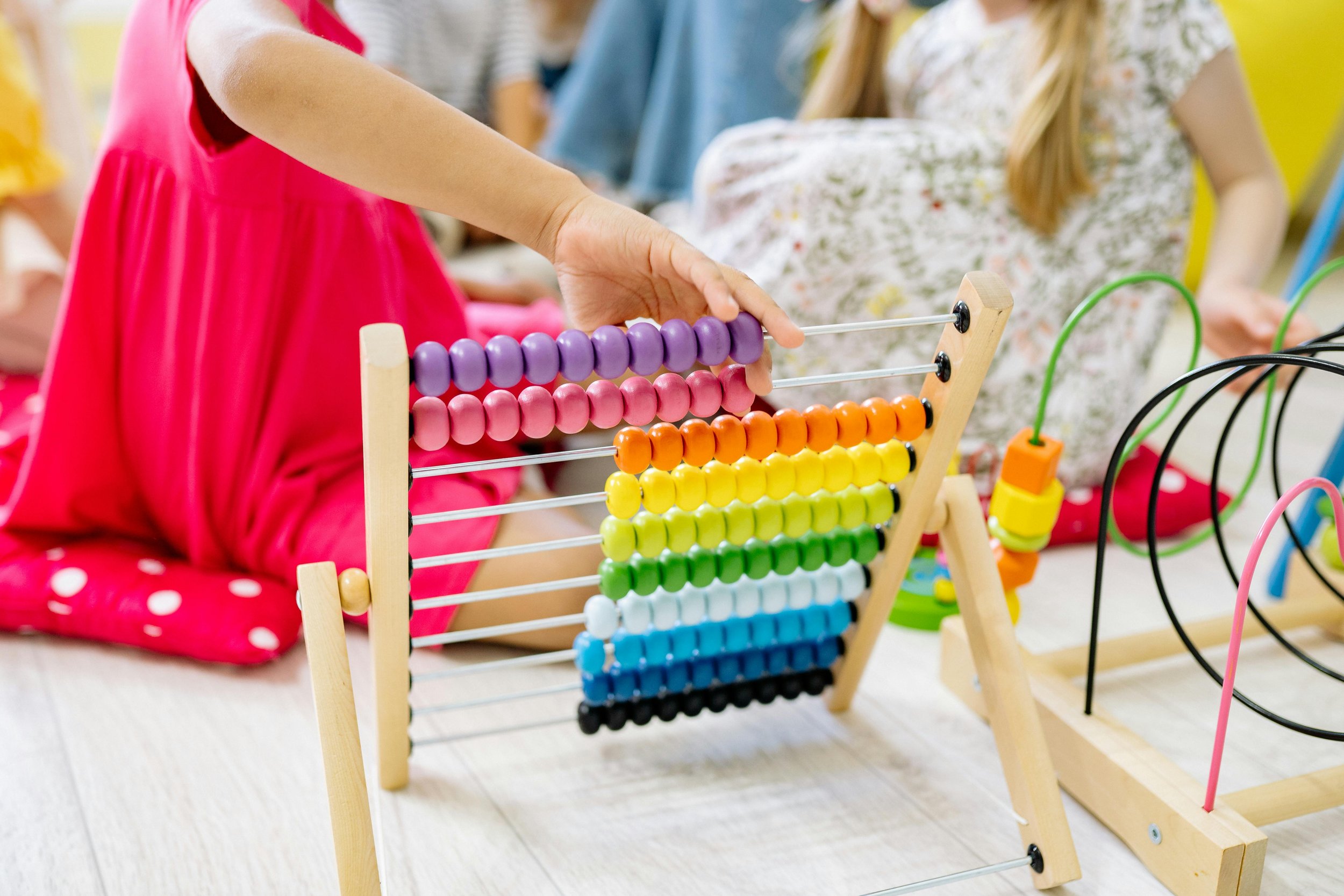 Children playing with a rainbow abacus at an ABA center