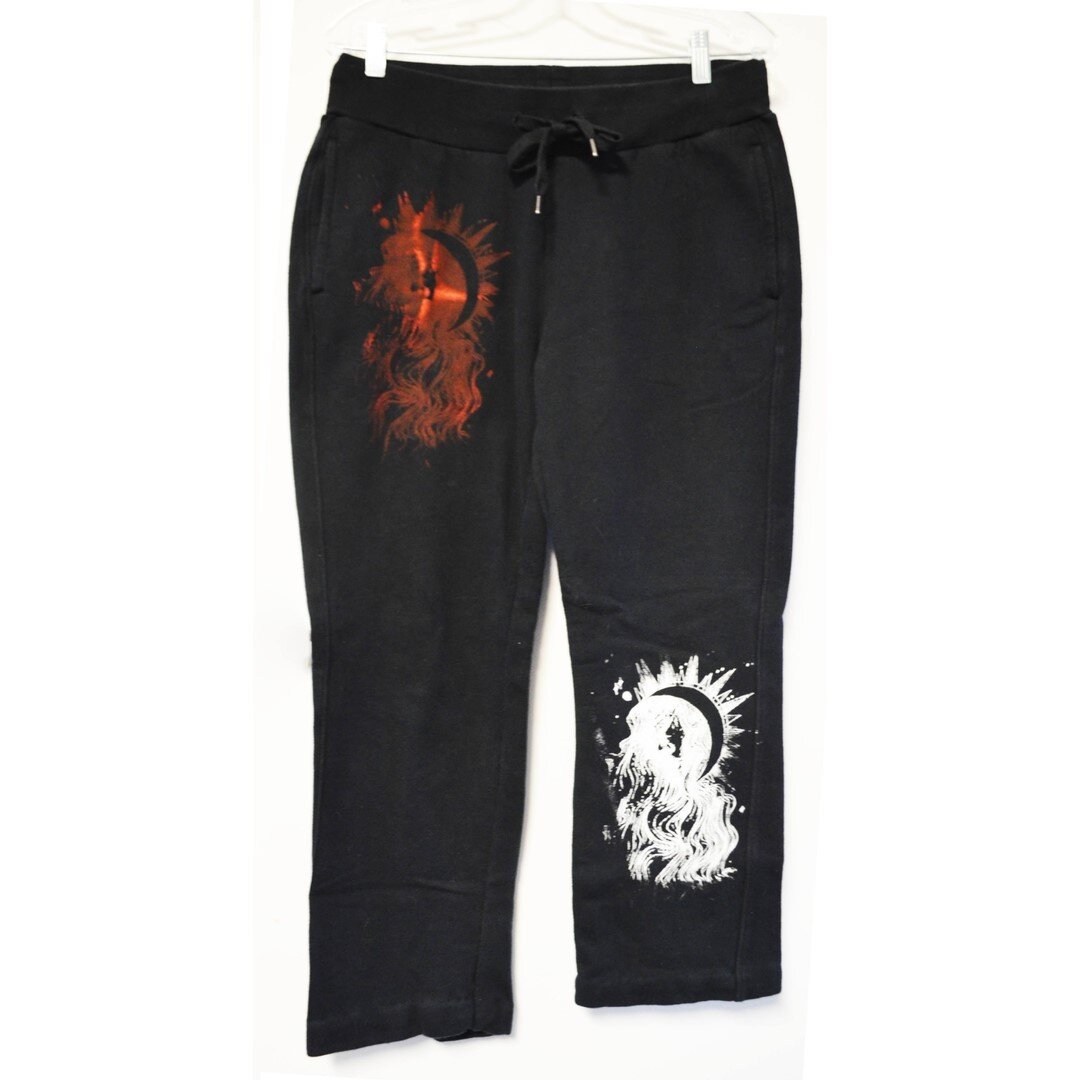 Today's feature is the Lune sweatpants. At $65 CAD, Lune is a pair of black sweatpants with white and red prints of The Moon tarot card. On the back is a sex sigil. One leg is rolled up in the photo. The waist is adjustable with a drawstring.⠀⠀⠀⠀⠀⠀⠀⠀