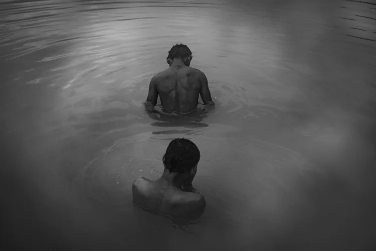 Due figure di spalle immerse nell’acqua