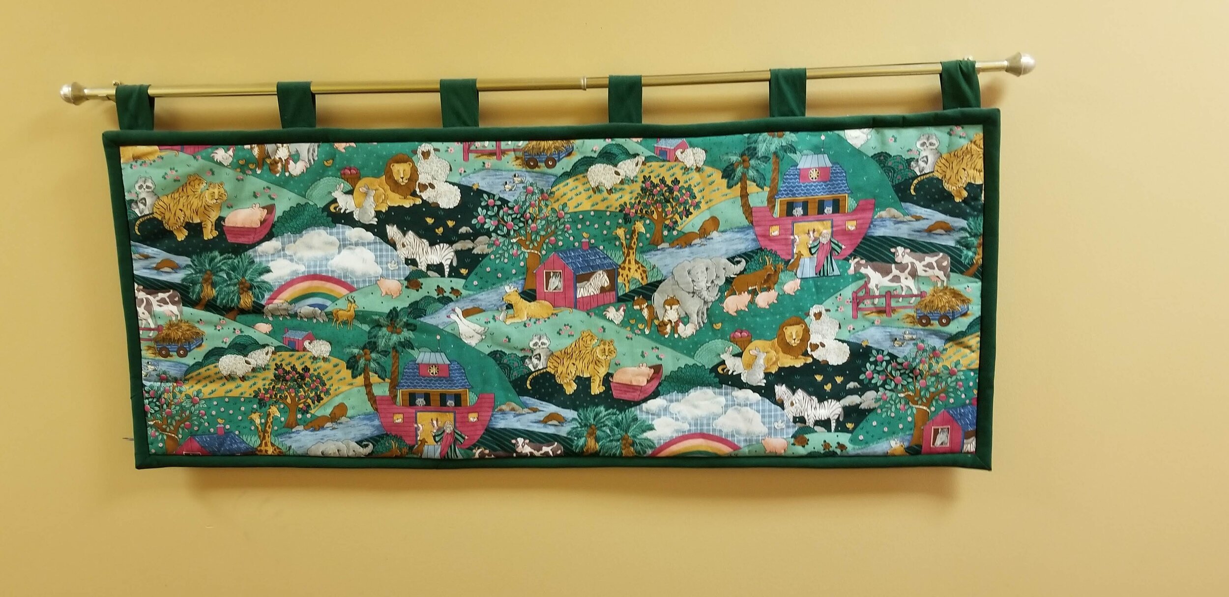 Colorful wall tapestry depicting a scene with animals and Noah's Ark, including lions, tigers, elephants, and a rainbow.