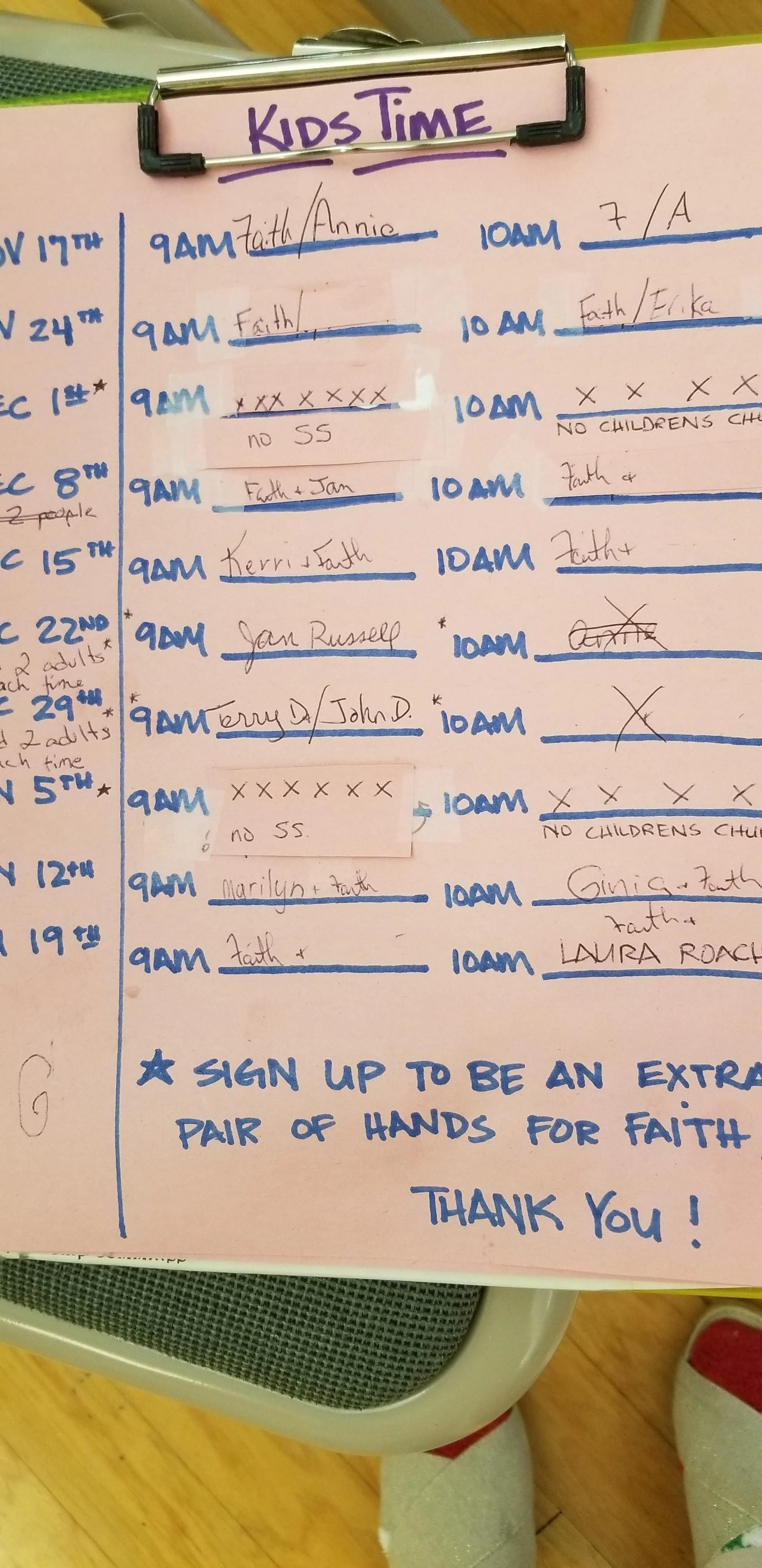 Clipboards with a pink sheet labeled "Kids Time," featuring a schedule with handwritten names, dates, and times, divided into 9 AM and 10 AM slots. Additional notes and a call for volunteers are included.