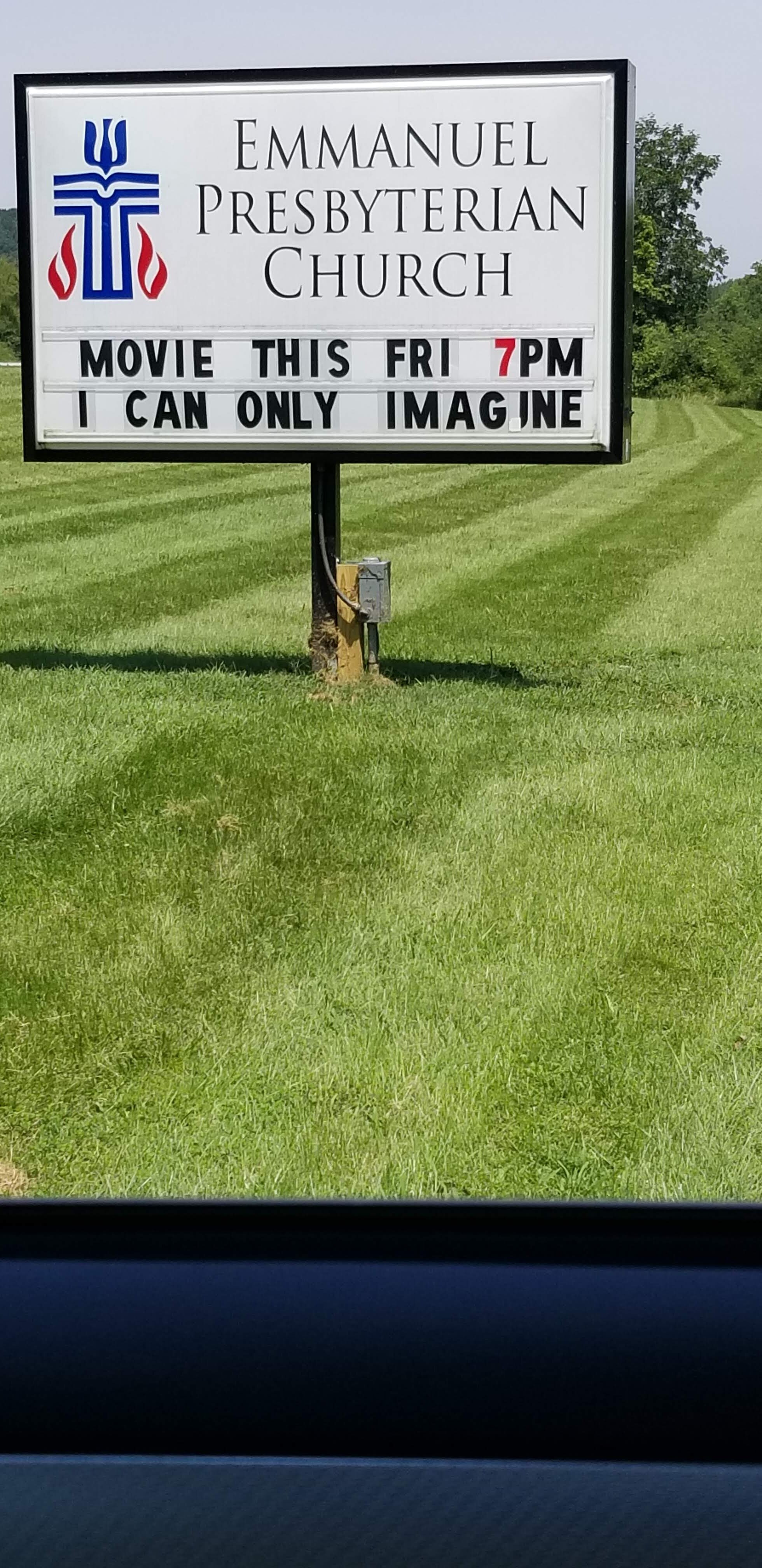 Sign for Emmanuel Presbyterian Church advertising a movie screening of "I Can Only Imagine" on Friday at 7 PM, set on a grassy field.