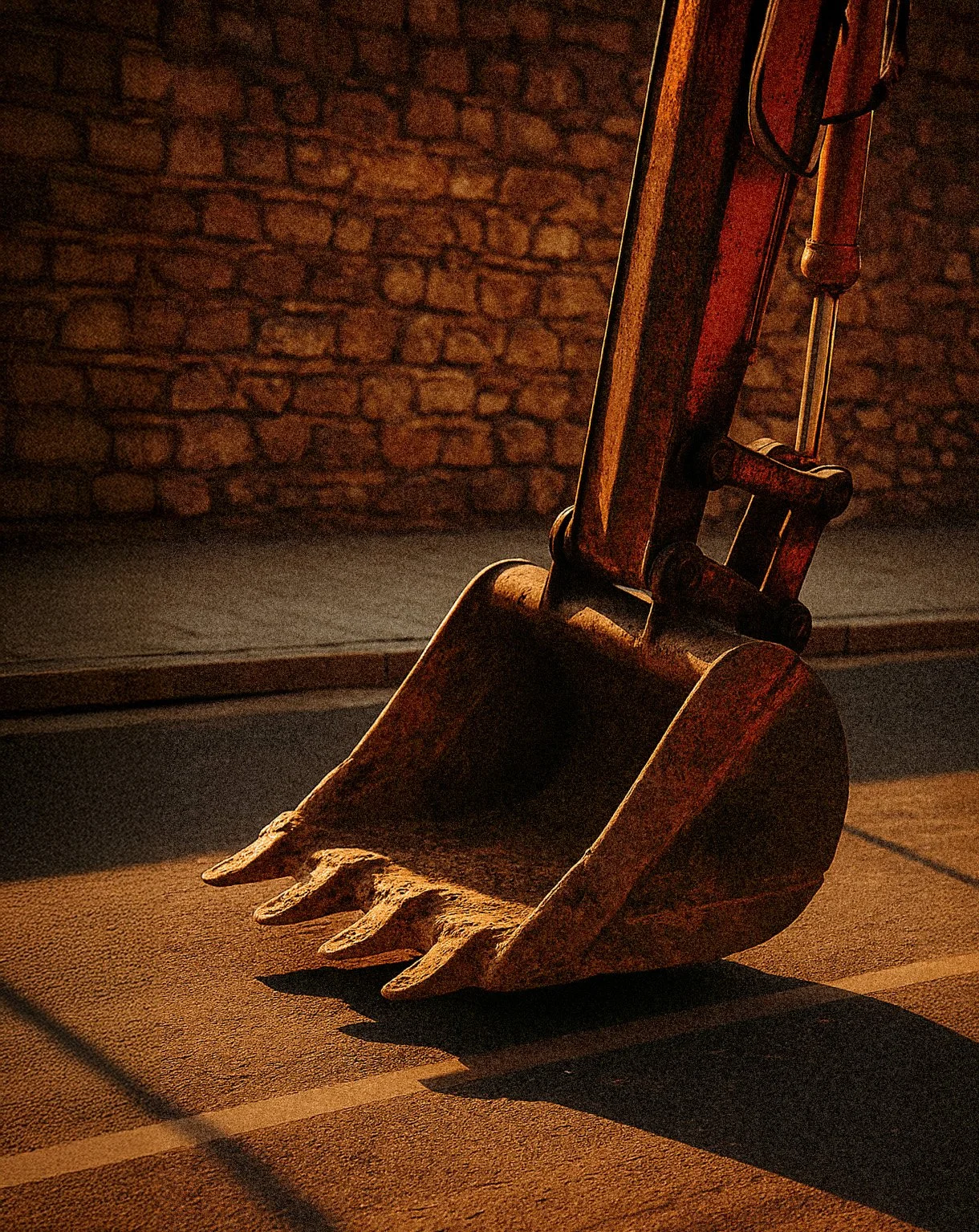 Close-up of an excavator bucket on a concrete surface, representing professional digger hire and earthworks services offered by Auckland Concrete Layers.