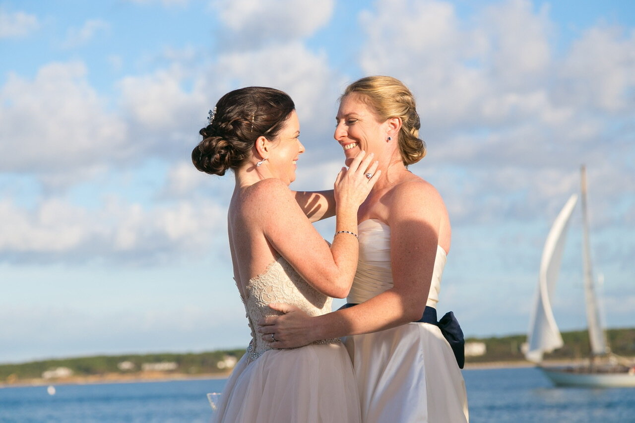 Two brides with a sailboat sailing by