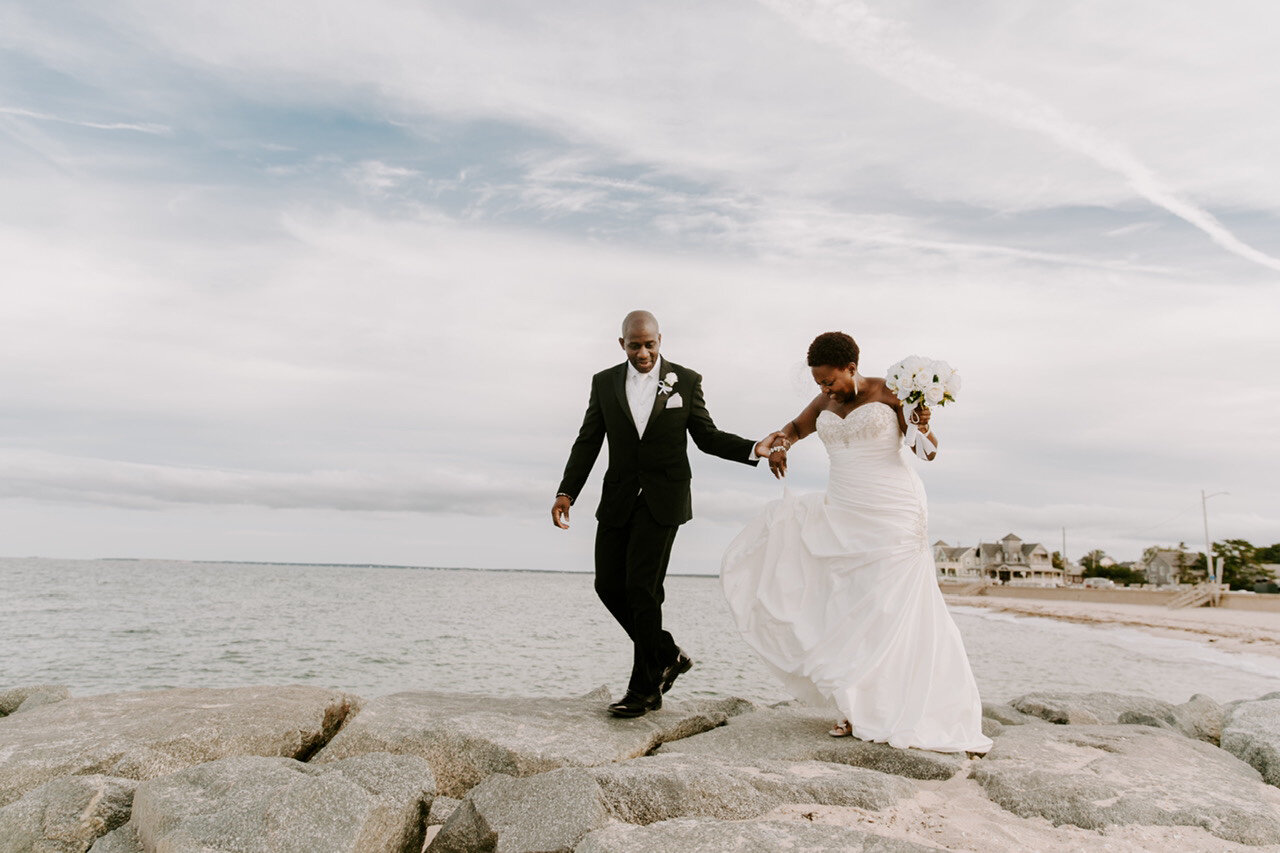 A couple walking down the rocks on the beach