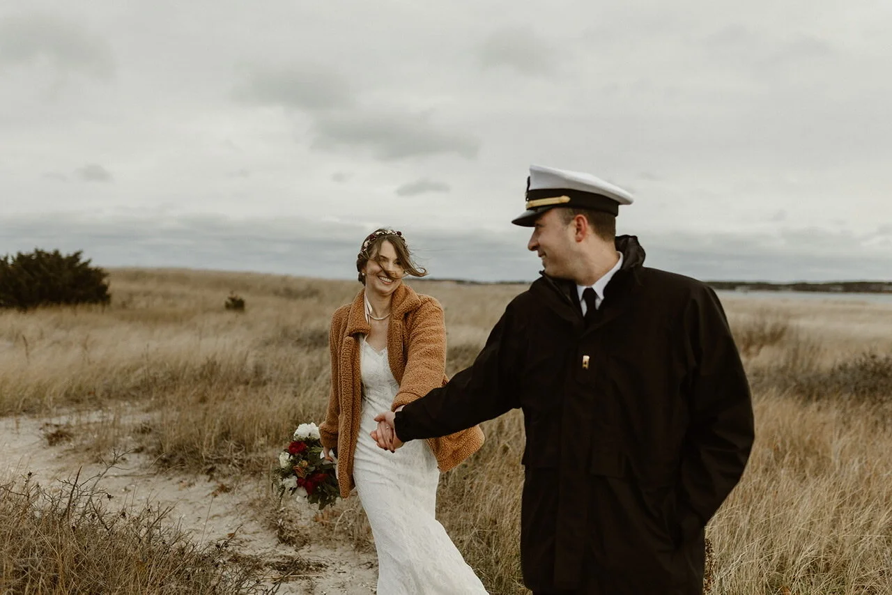 Bride in white and Groom in uniform looking back at the bride.