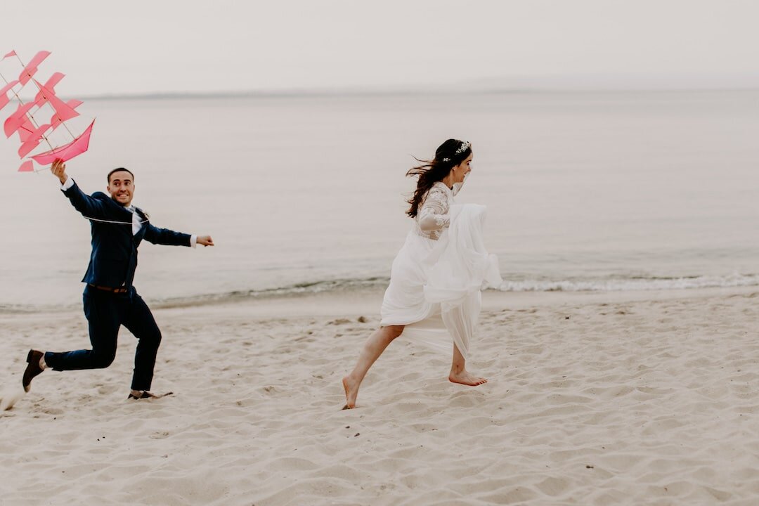 Couple flying a kite on Marthas Vineyard running down the beach.jpg