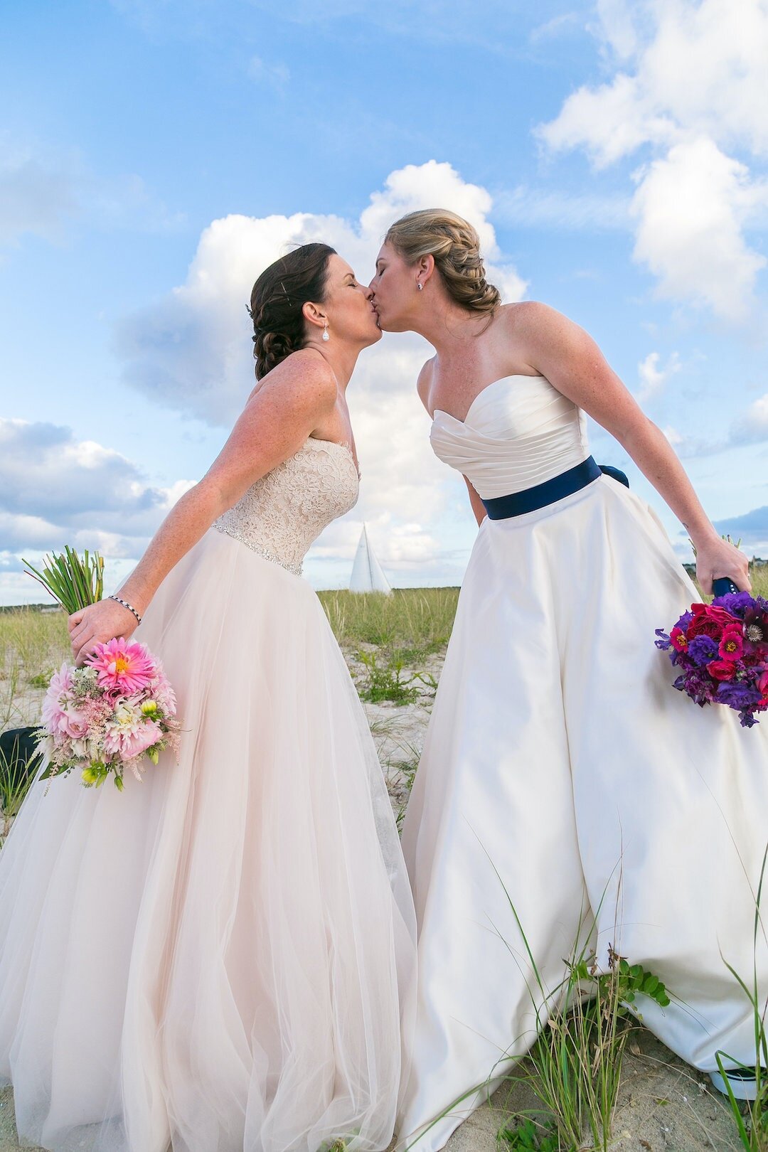 couple kissing after wedding holding bouquet.jpg