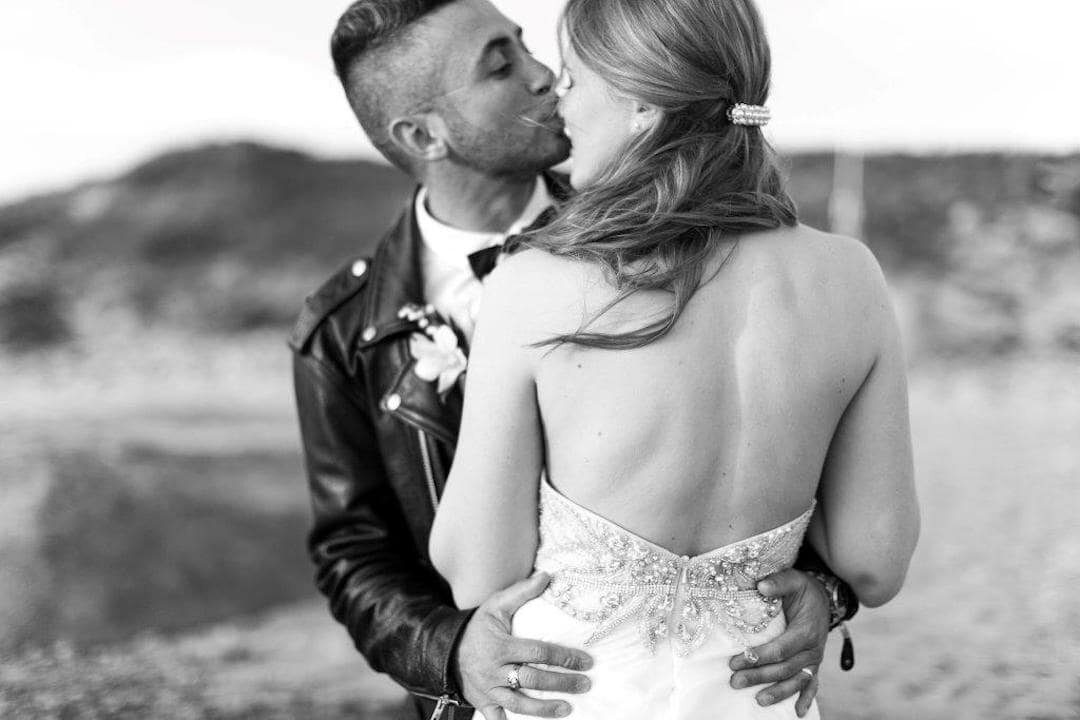 couple kissing on the beach after wedding.jpg