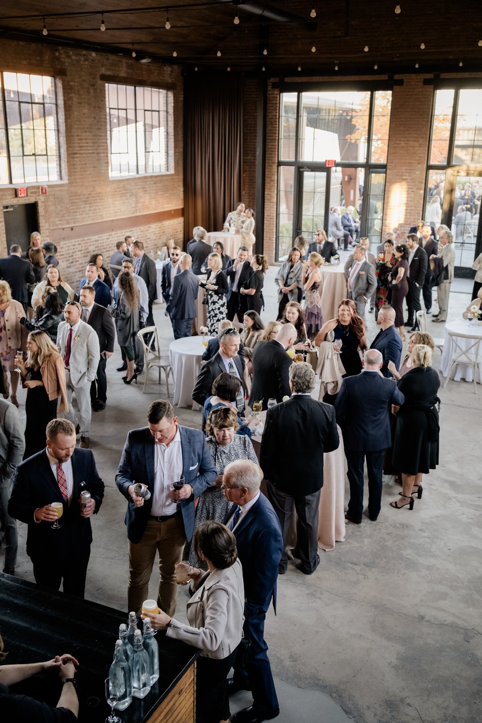 Wedding attendees mingle inside the brick building Hutton Hall 