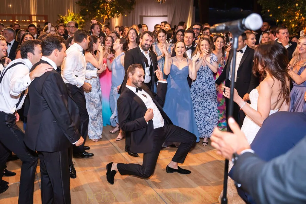  The groom bends at one knee to air guitar while dancing 