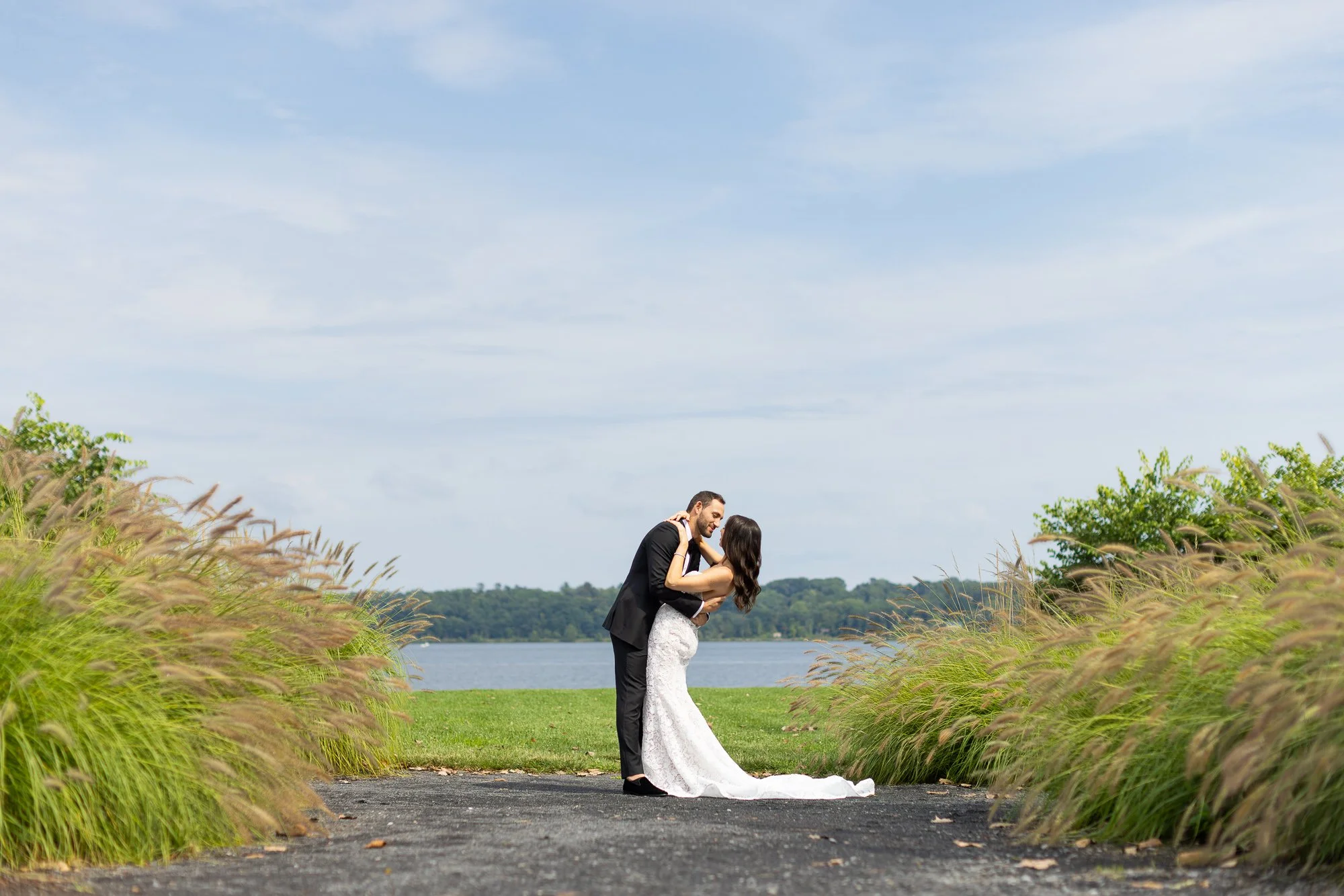 Bride and groom embrace near the river's edge