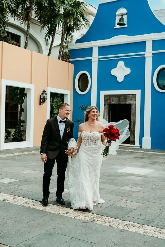 Candid wedding portrait in front of blue church at Dreams Tulum Resort & Spa.