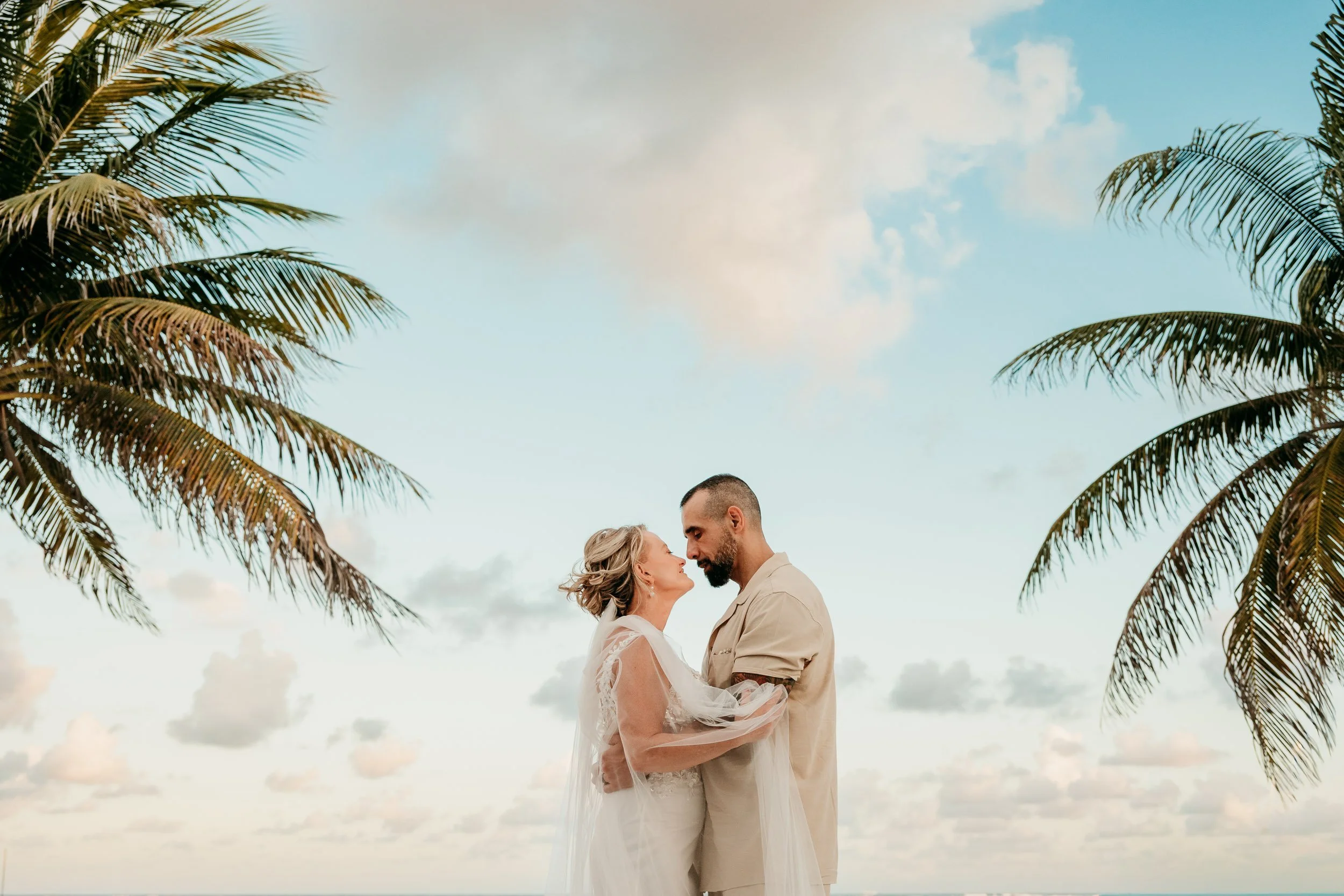riviera-maya-wedding-photographer-couple-standing-between-palm-trees.jpg