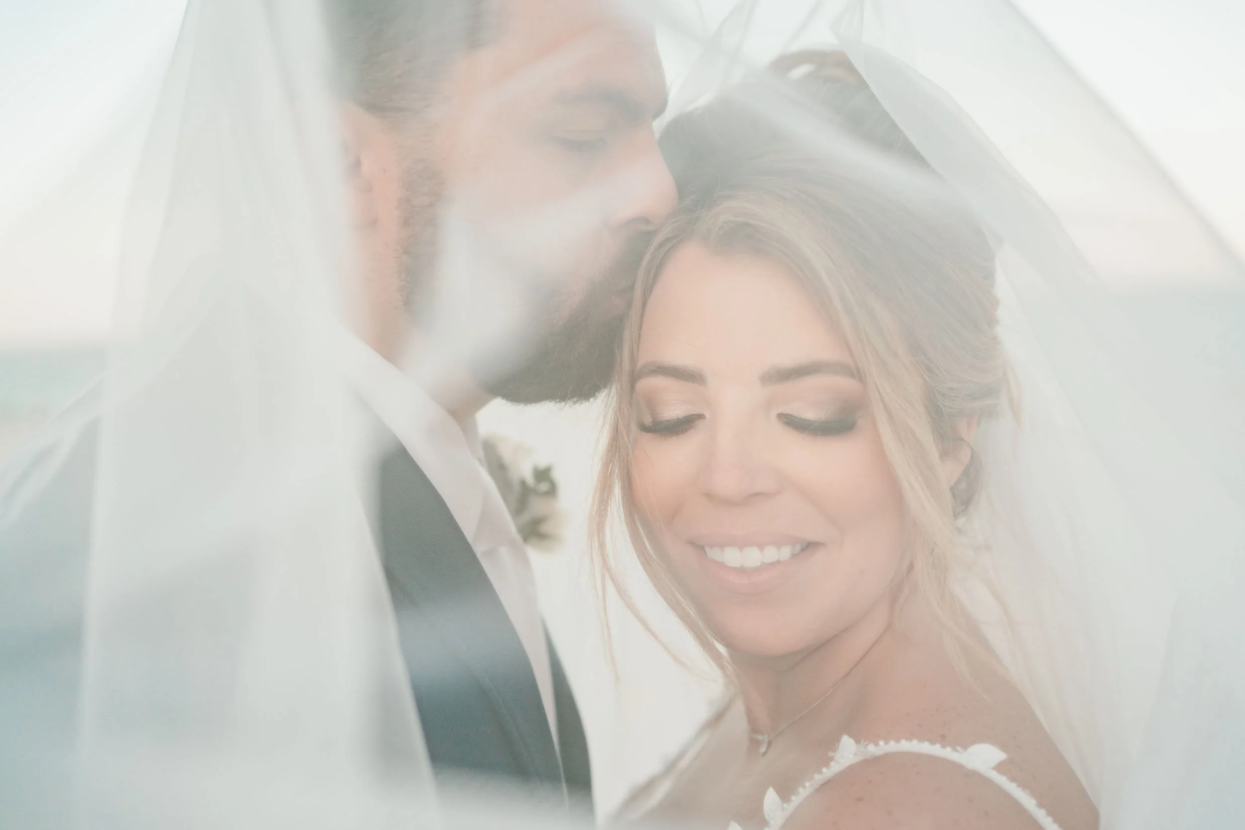 secrets-playa-mujeres-wedding-photographer-groom-kissing-brides-forehead.jpg