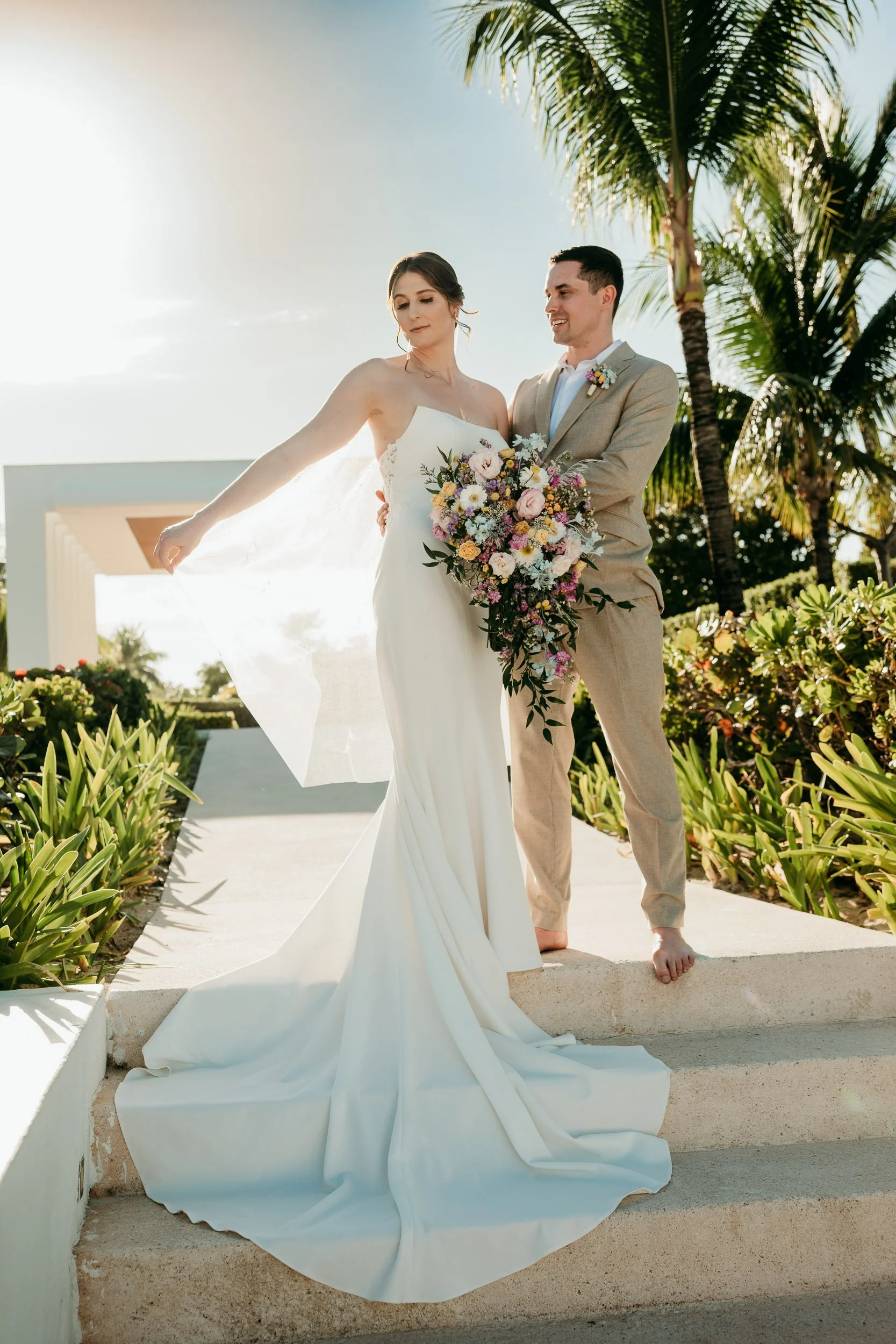 finest-playa-mujeres-wedding-photography-cancun-groom-holding-bride-palm-trees.jpg