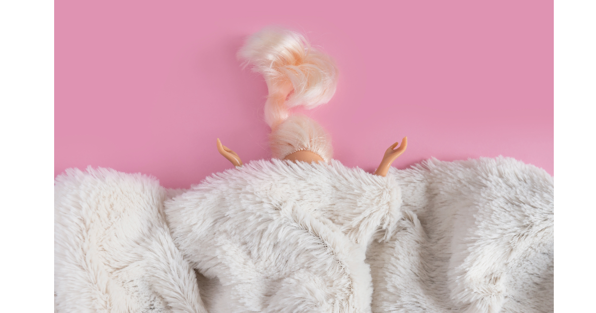 Leksakssko som är omgiven av rosa, fluffy material och ett rosa bakgrund.