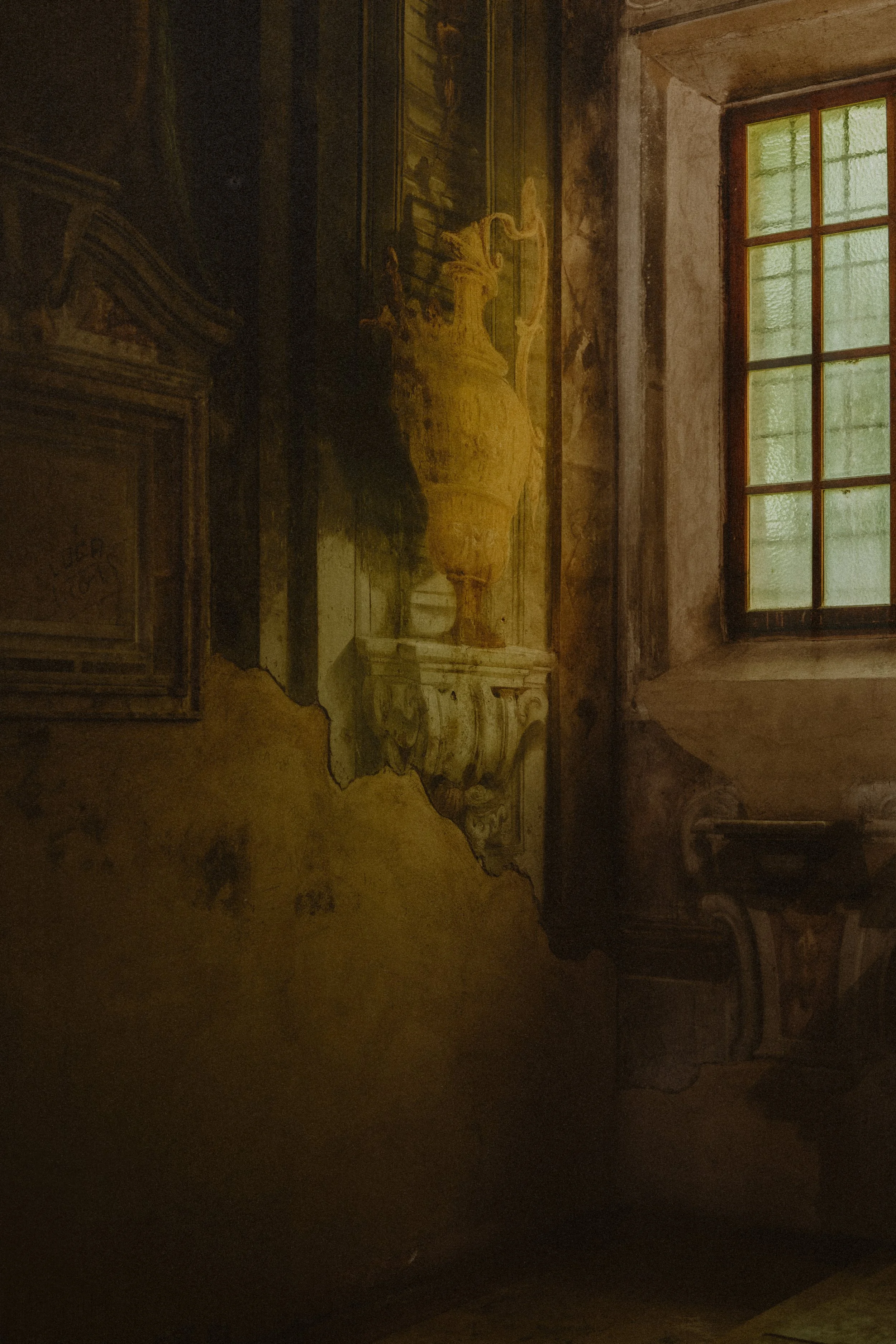 Peinture ancienne endommagée sur un mur intérieur avec une fenêtre en arrière-plan