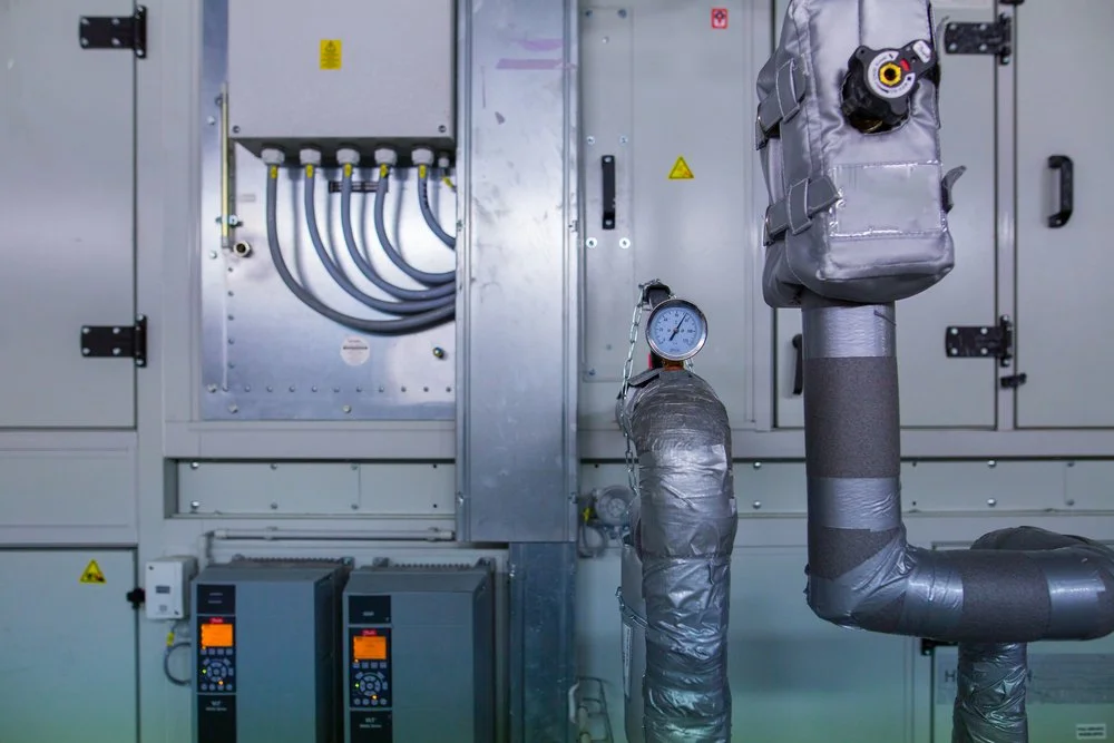 Panel de control eléctrico y tuberías grises aisladas con medidores parte de sistemas de enfriamiento modernos.