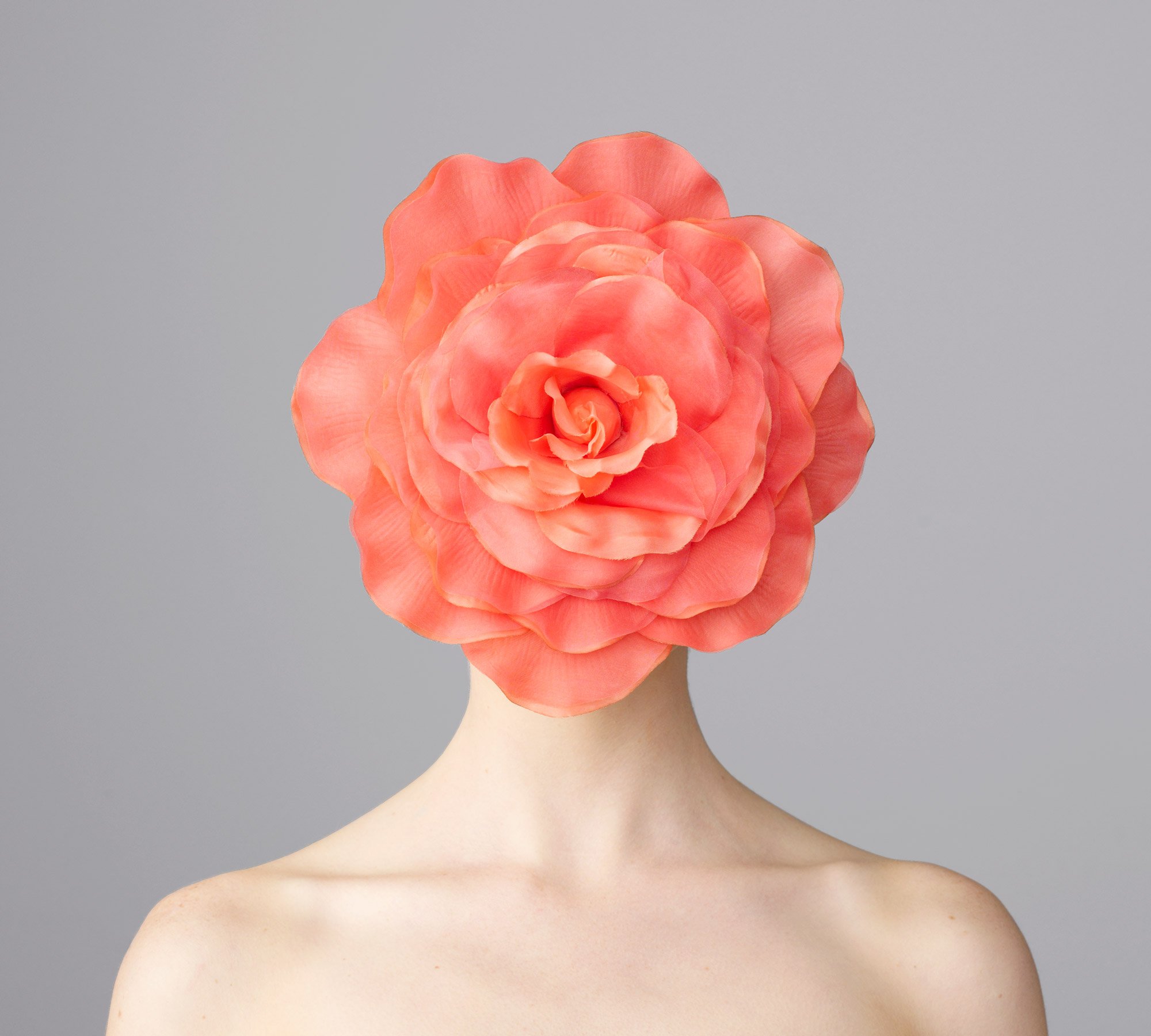 Studio portrait of women with orange flower over her face from the series 'Curiosity' by photographer David.A.Knight ©