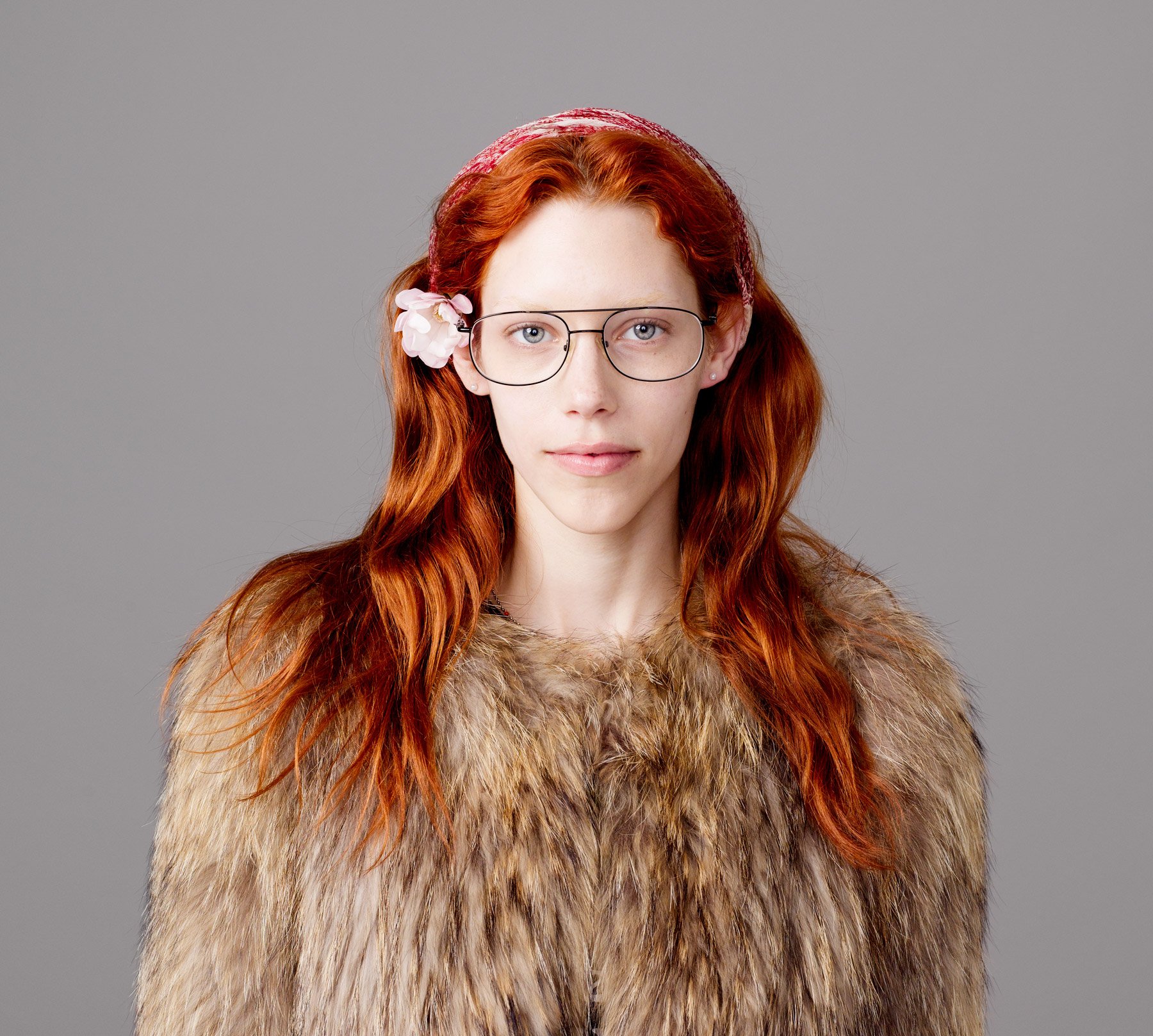 Portrait of  German Fashion model Eilika Meckbach with flower in hair, faux fur coat, glasses, head scarf and flaming red hair by Sydney photographer David.A.Knight ©