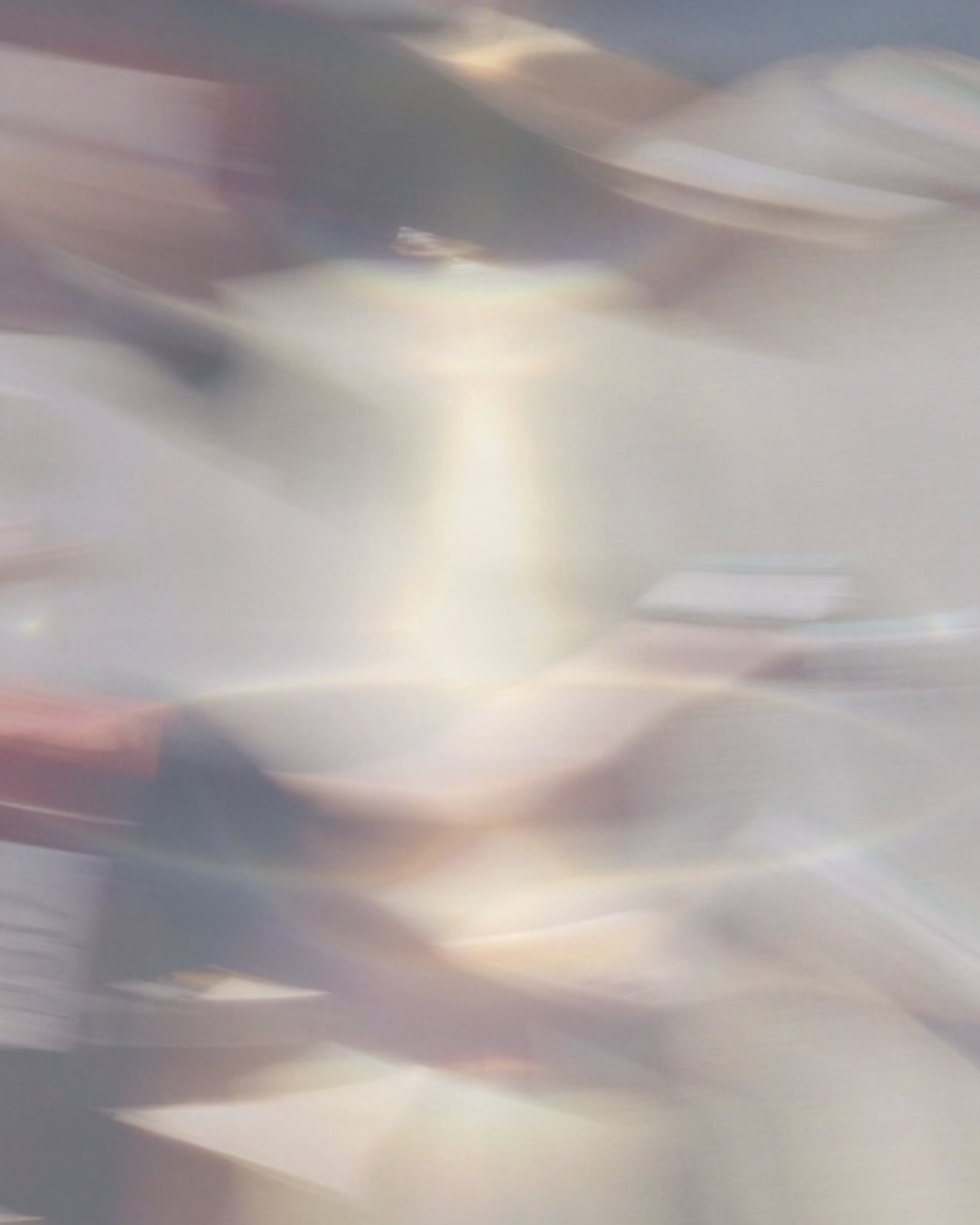 Blurred image of a metallic or shiny surface with abstract streaks and reflections.