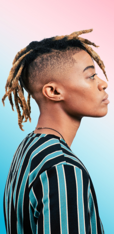 Person with locs wearing a striped sweater