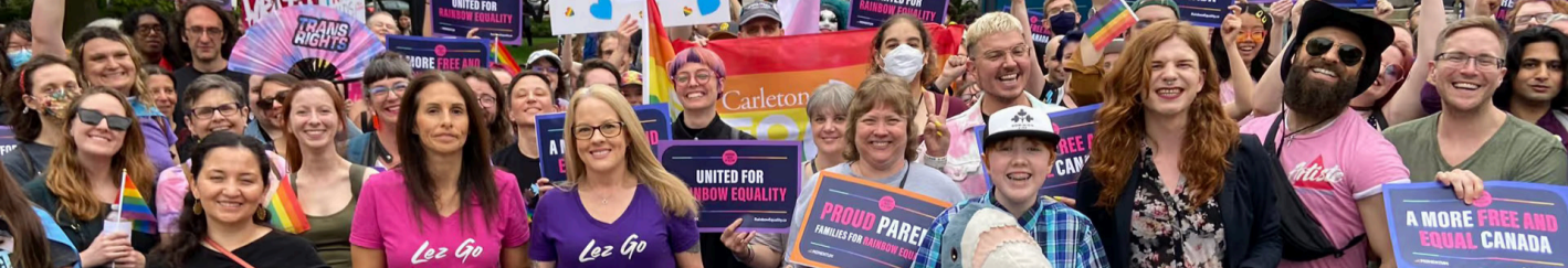 Crowd of activists holding pride and trans rights signs