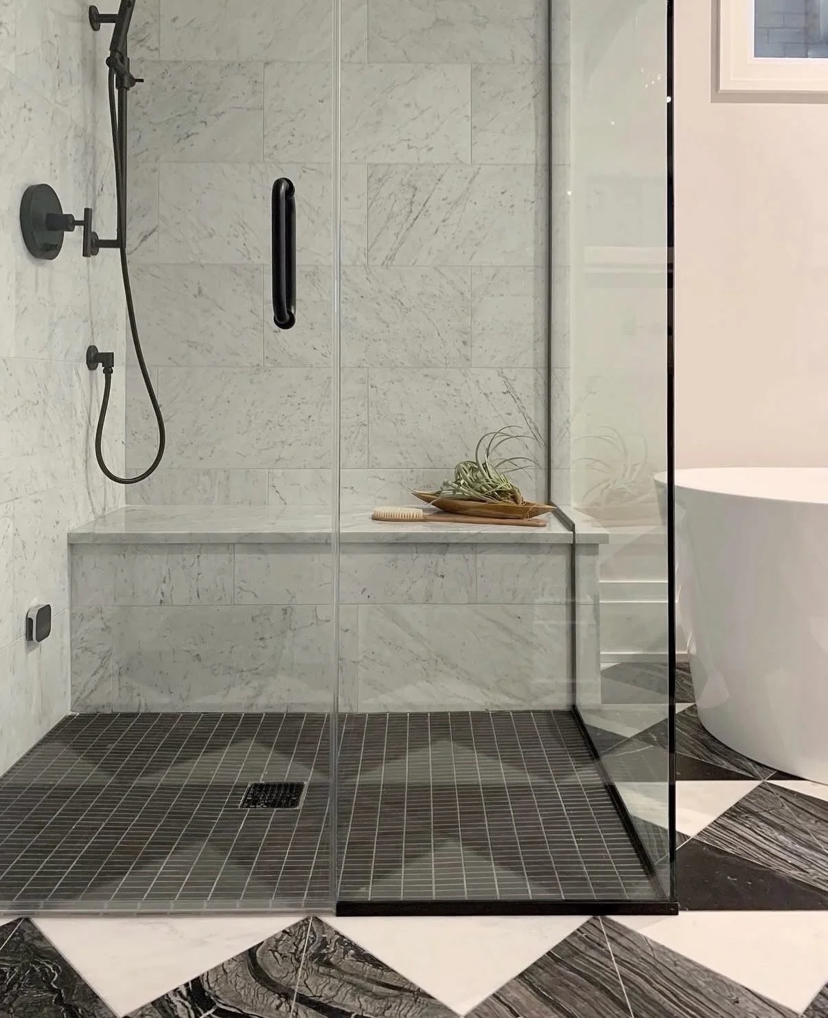 Great design is not defined by time. It endures. 🤍 🖤

We love this Fulton Market primary bath just as much today as when it was first completed. All designed with intention, a white oak vanity, arched mirror, and a custom marble floor composed of t