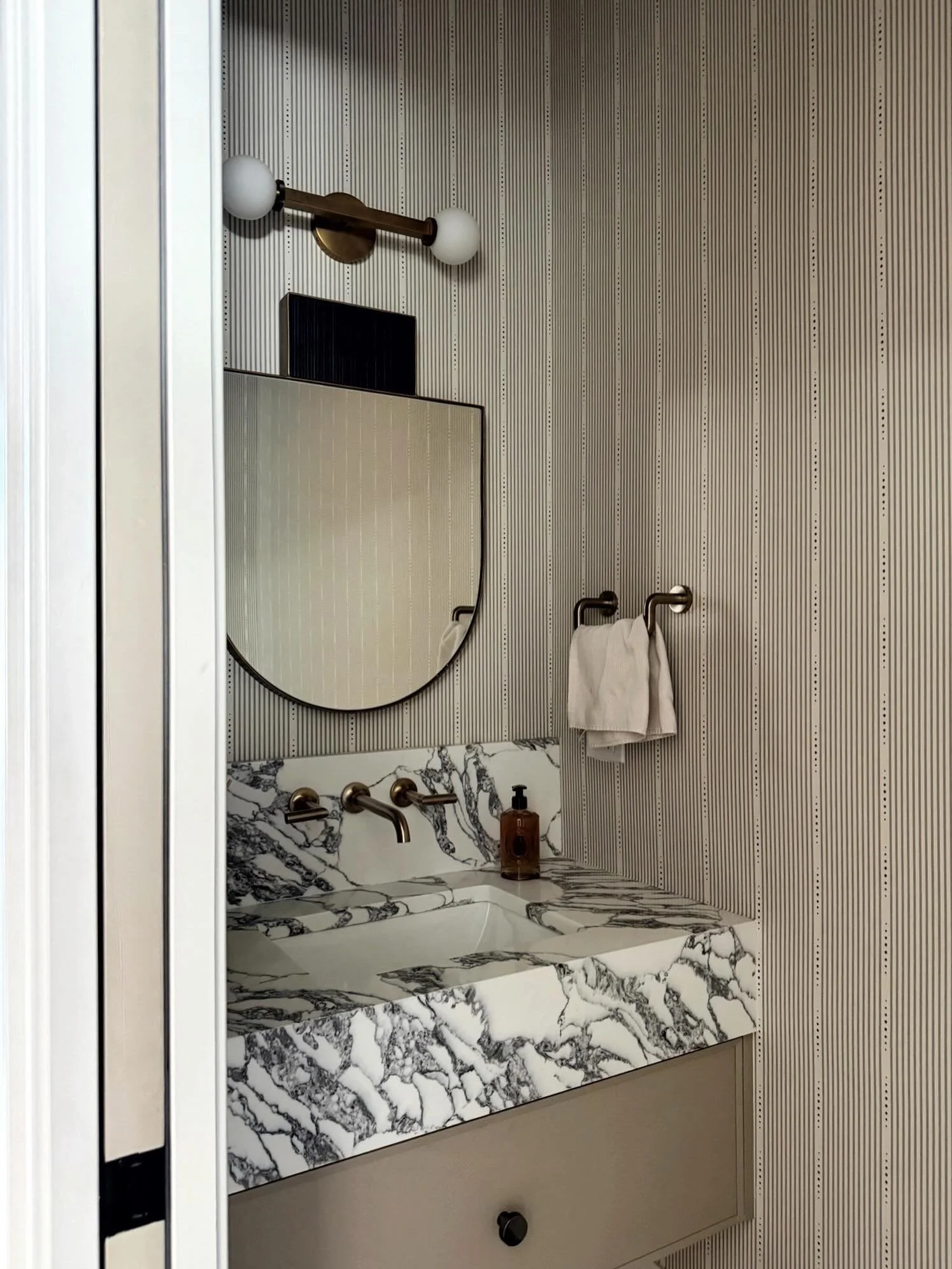 Sneak peek of a powder room from our latest West Town new build project! Bold veining in Arabescato marble, tailored pinstripe walls, and sculptural styling moments make this neutral palette anything but ordinary. Full project reveal to come&hellip;s