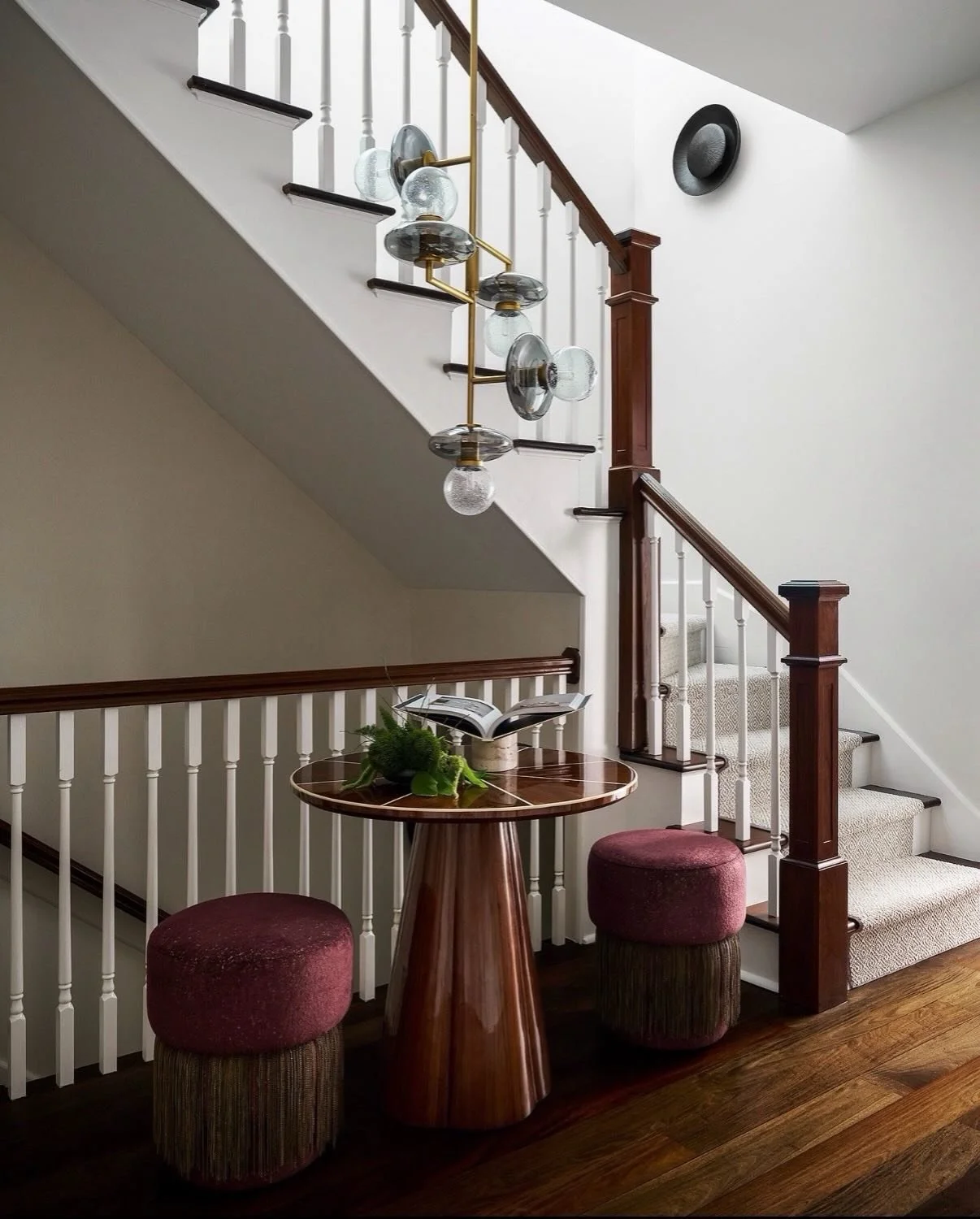 Designed to pause the eye. This staircase landing at our Gold Coast project proves that transitional spaces deserve just as much intention &mdash; layering soft forms, reflective surfaces, cascading light, and ottomans that turn a quick pass-through 
