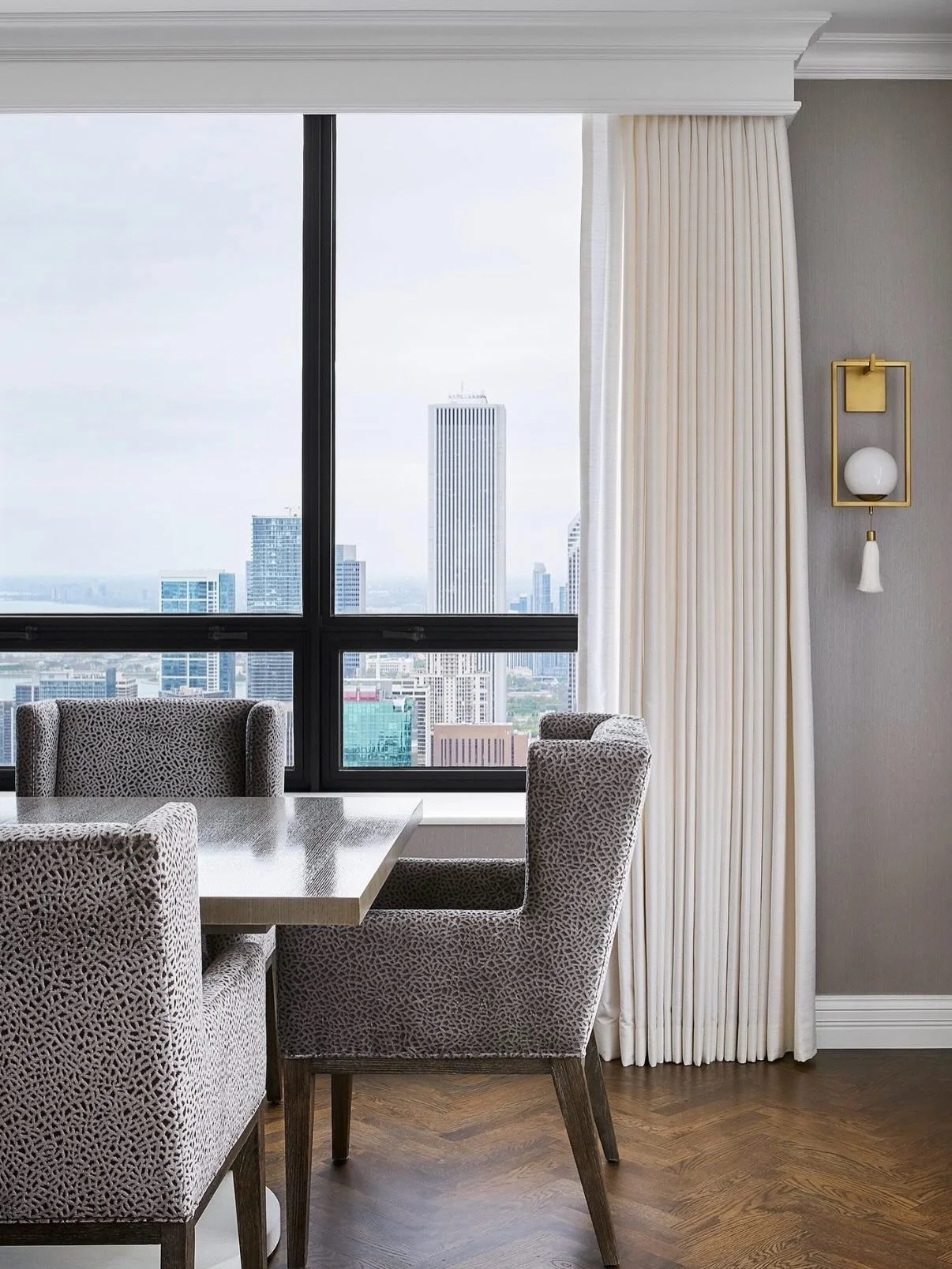 Downtown skyline views set the tone for this elegant dining space. 🏙️

To fulfill our clients&rsquo; request for moments of glam, we paired chic host chairs with striking lighting that adds polish and personality. Positioned alongside the windows to