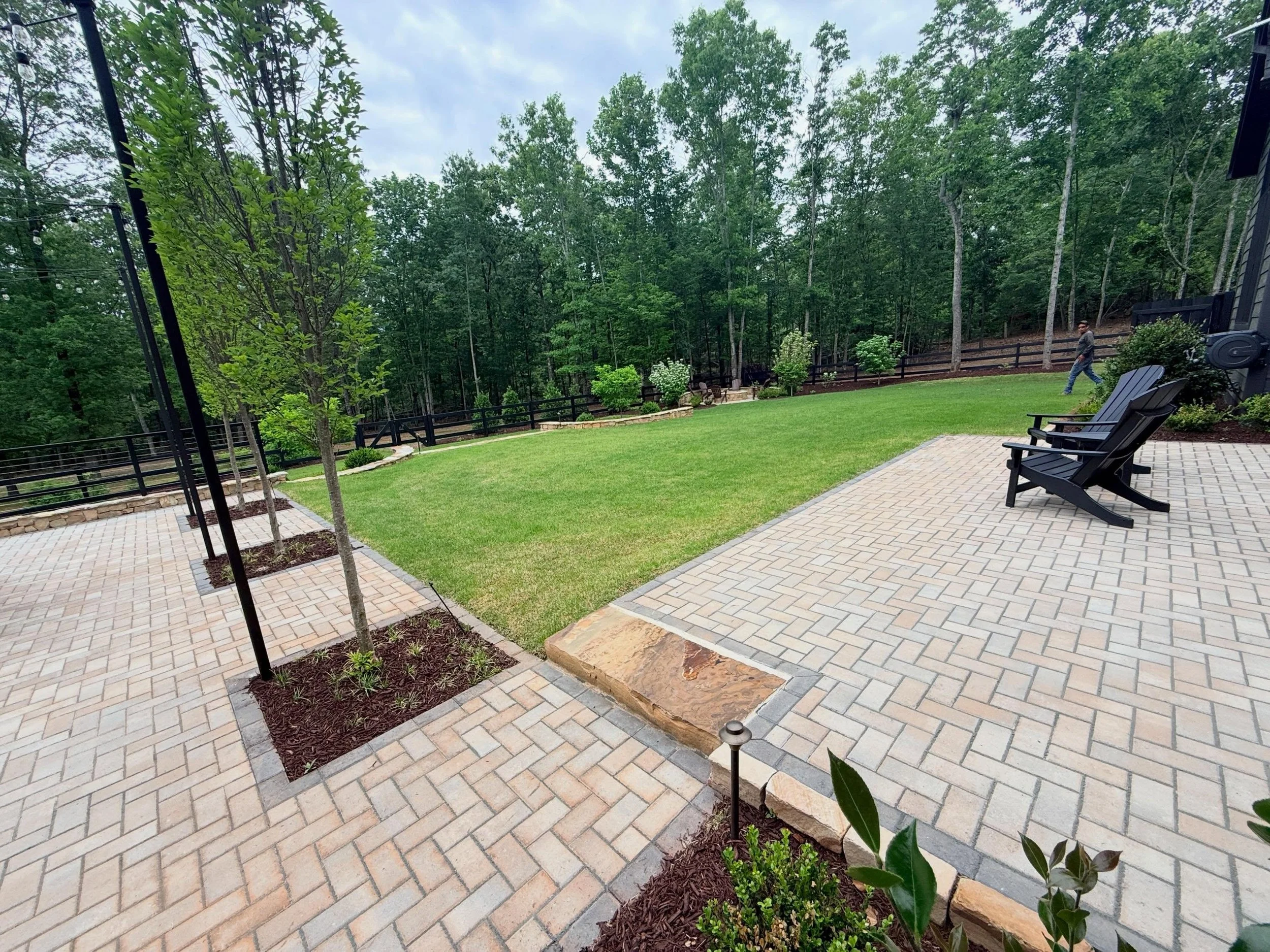 From blank canvas to fully integrated outdoor living.

This project included custom patios, veneered retaining walls, raised garden beds, concrete steppers, irrigation, lighting, sod, planting, and a custom fire pit area built using stone from the ho