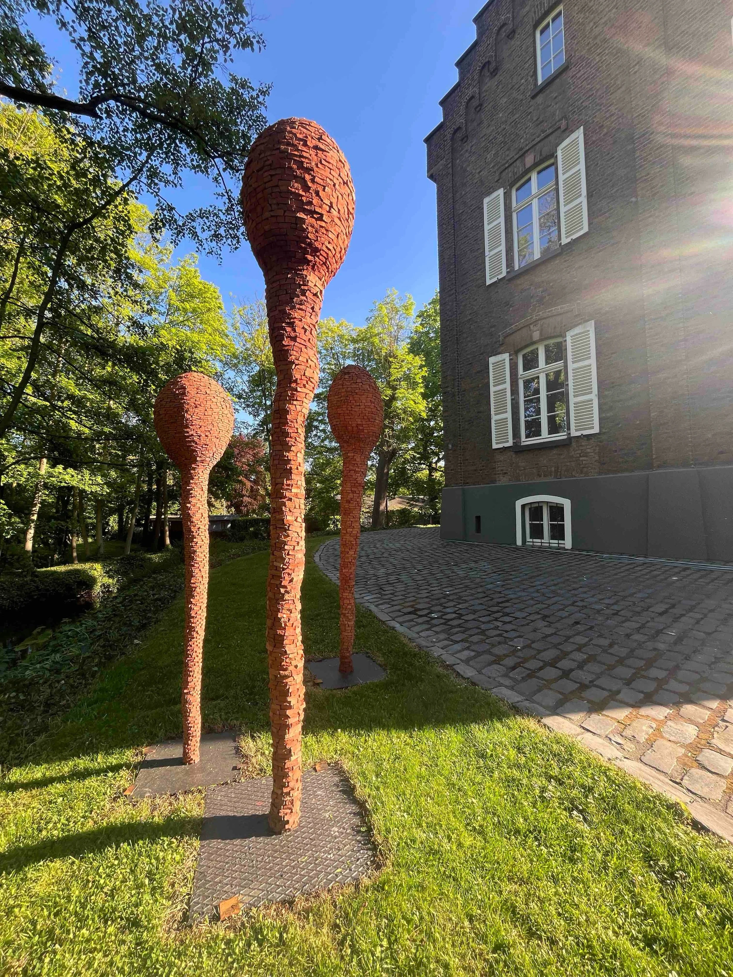 Im Au&szlig;enbereich der Kunstinitiative @kunstwurzelnundfluegel gibt es diesen Sommer die Ziegelskulpturen von Reiner Seliger @reinerseliger.art zu entdecken. Mitten im Gr&uuml;n, umgeben von Natur stechen die Skulpturen mit ihrer Terrakotta-Farbe 